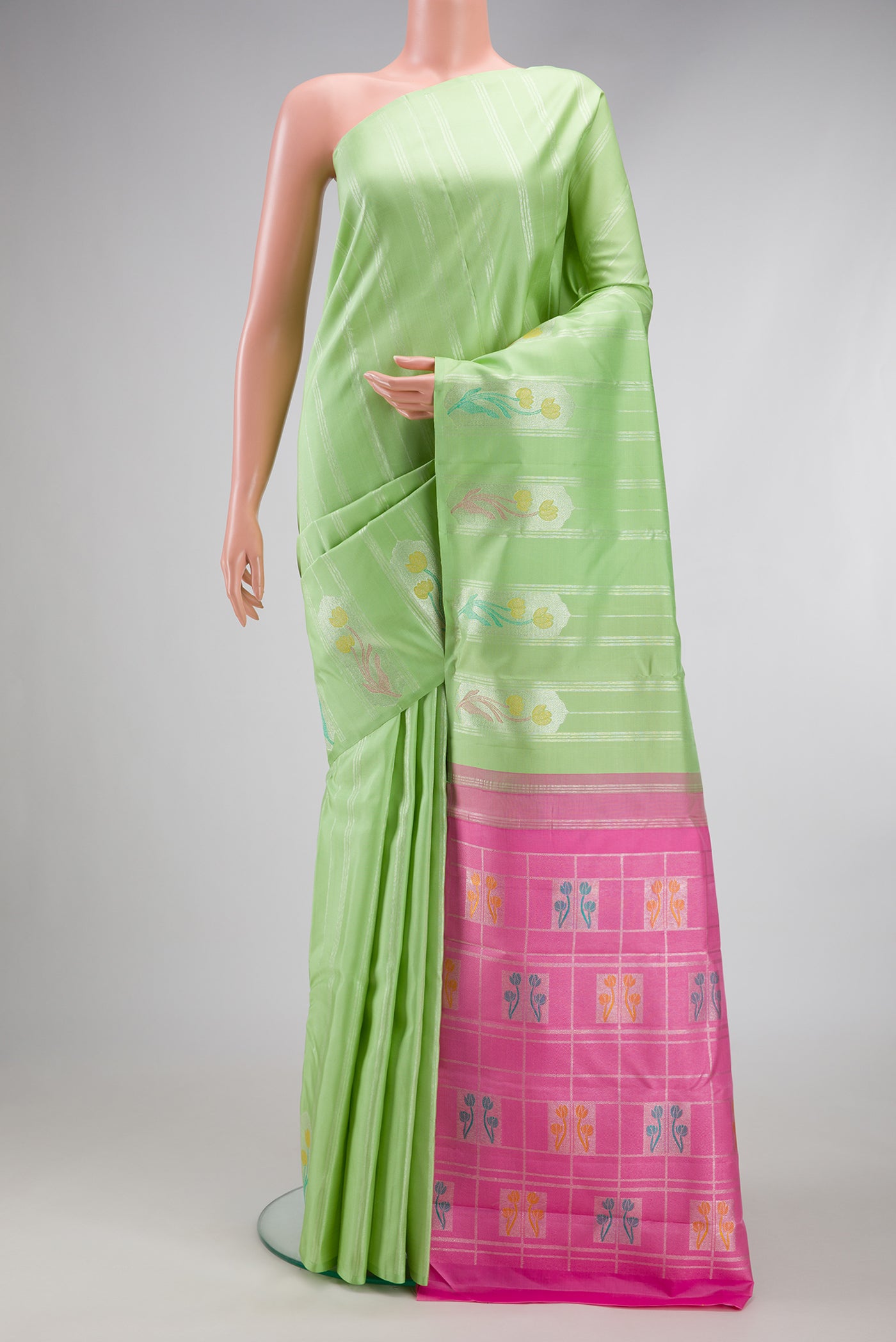 Pista Green Kanjivaram Silk Saree with Stripes on the body and Fancy Border.  displayed on a mannequin