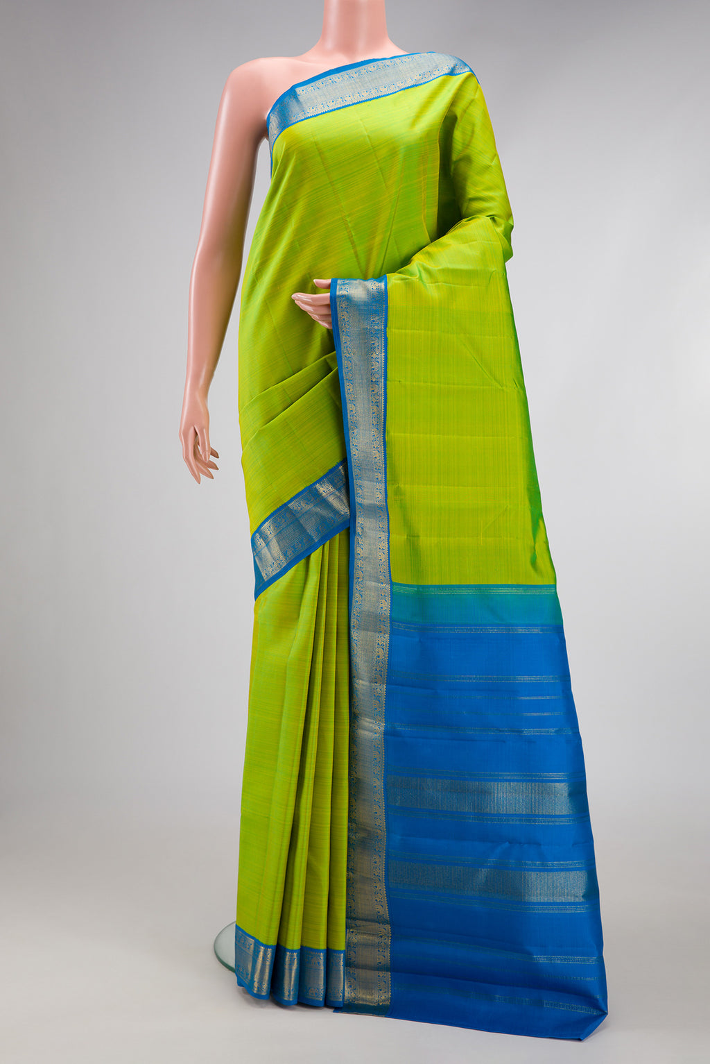 Parrot Green Kanjivaram Silk Saree with Plain Body and Zari Border.  displayed on a mannequin