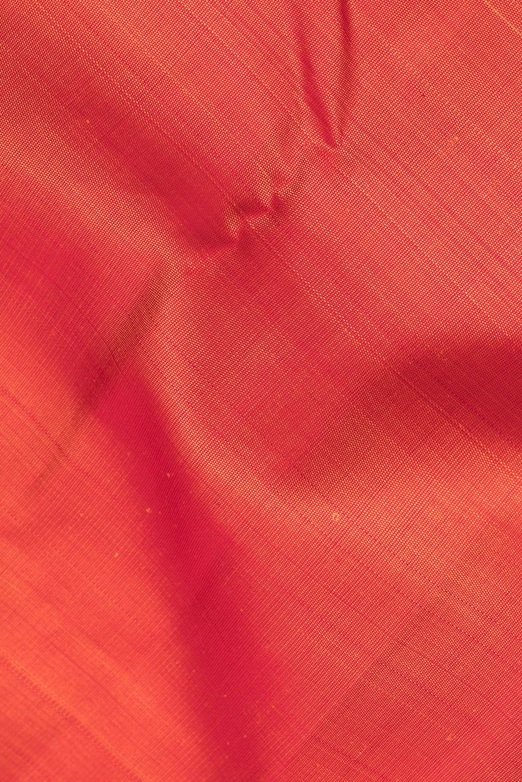 Close up of Pure Silk Orange Dual Tone Kanjivaram Saree with Plain Body and Zari Border.  displaying folds