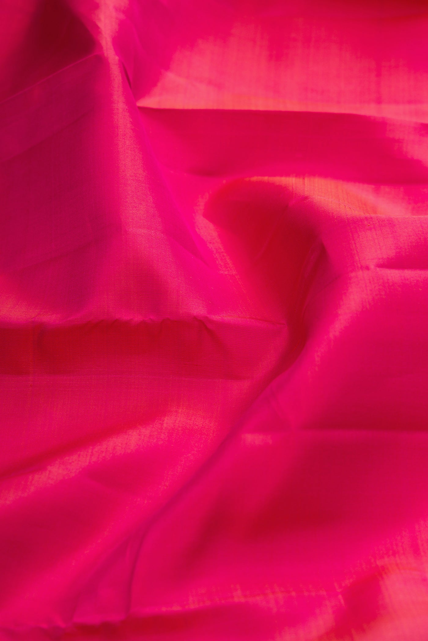Close up of Pink Kanjivaram Silk Saree with Plain Body and Zari Border.  displaying folds