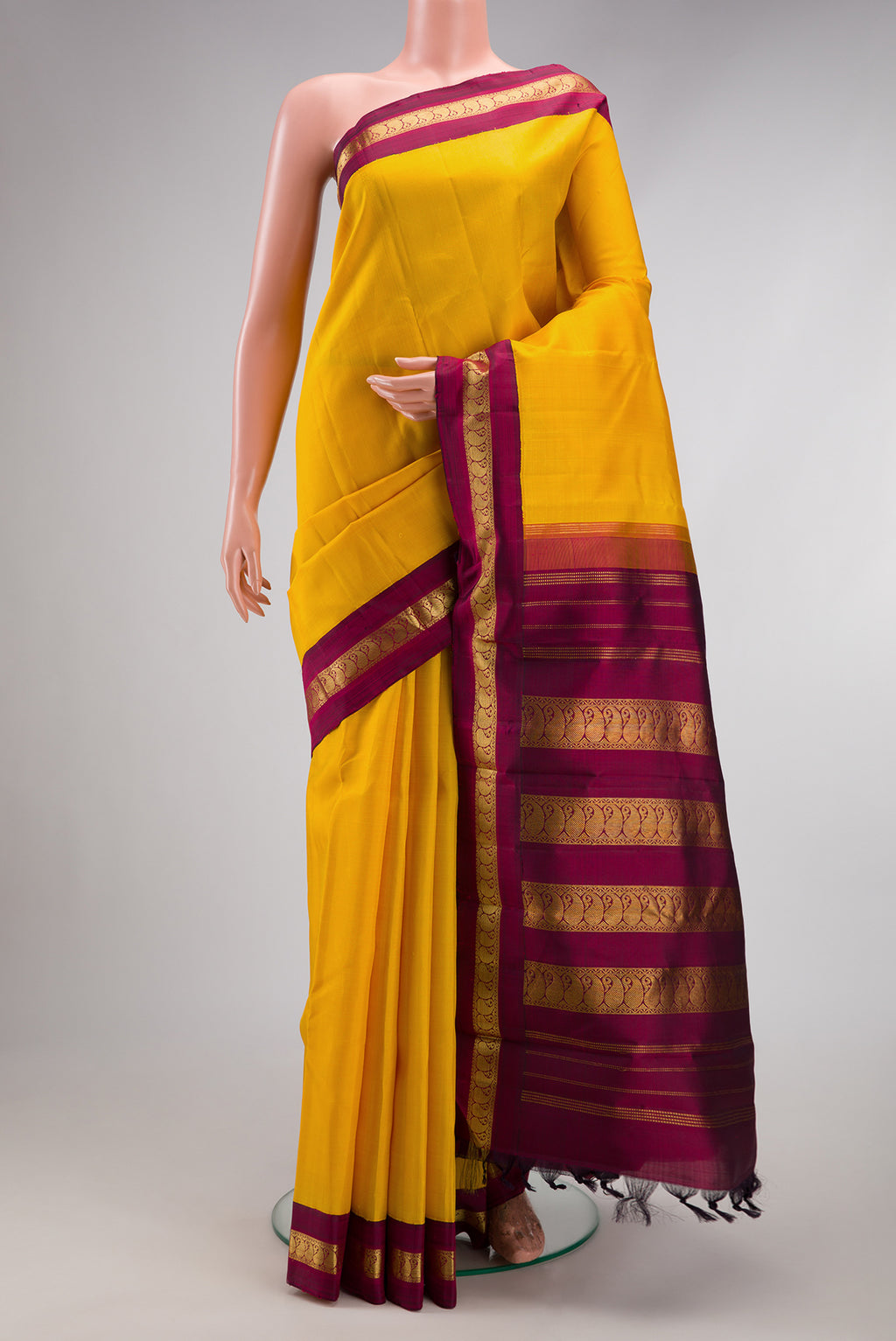 Pure Silk Pure Zari Yellow Kanjivaram Saree with Plain Body and Zari Border.  displayed on a mannequin