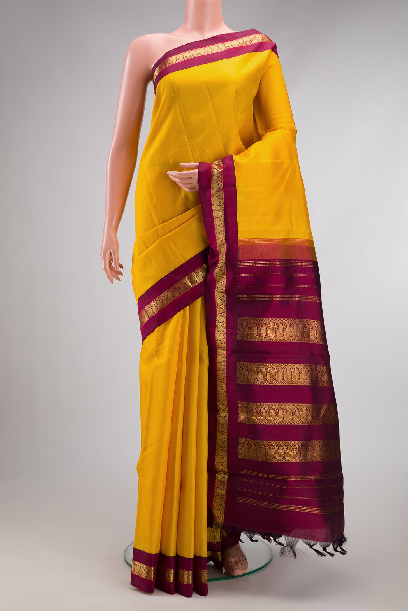 Pure Silk Pure Zari Yellow Kanjivaram Saree with Plain Body and Zari Border.  displayed on a mannequin