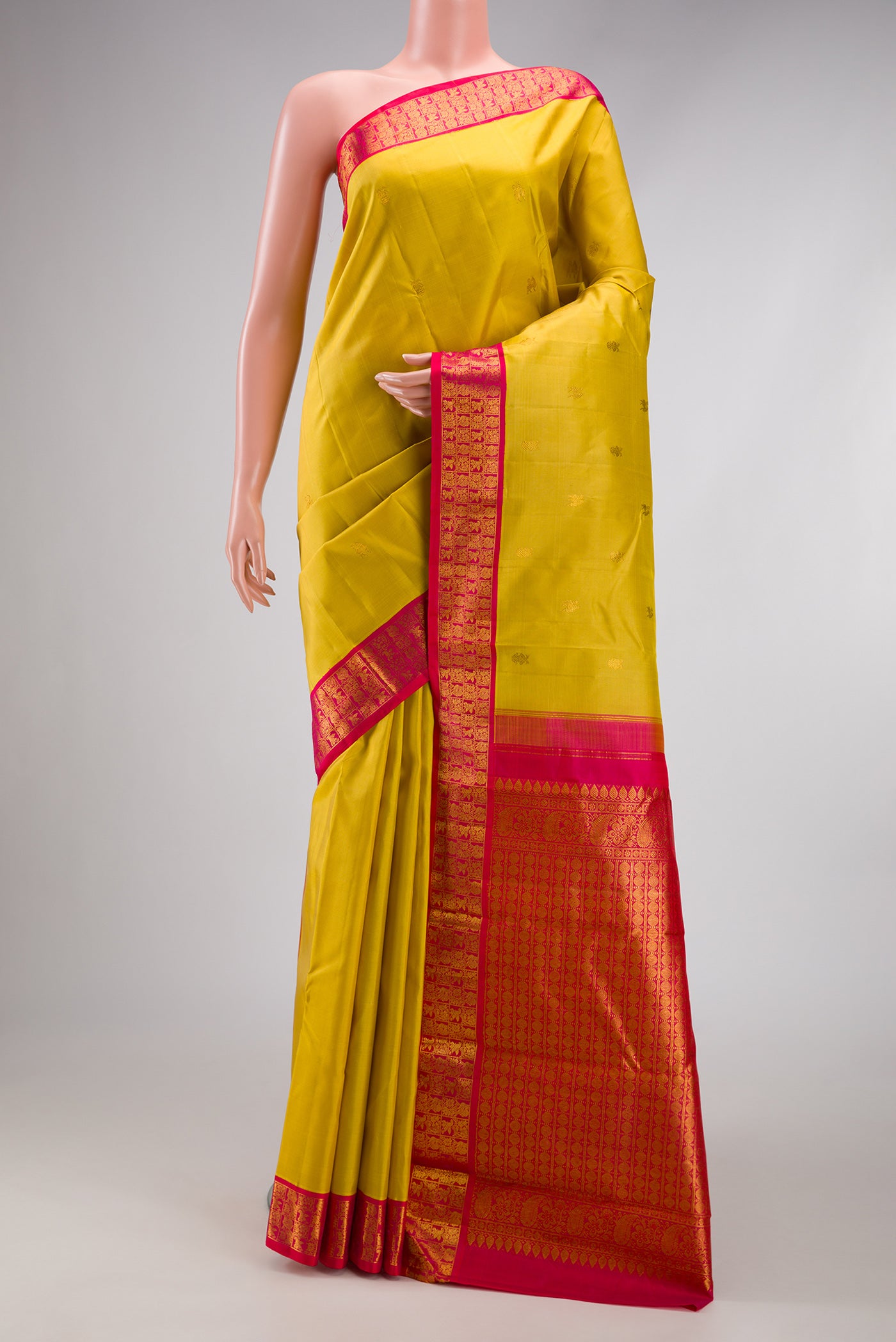 Yellow Kanjivaram Silk Saree with Zari Butta on the body and Zari Border.  displayed on a mannequin