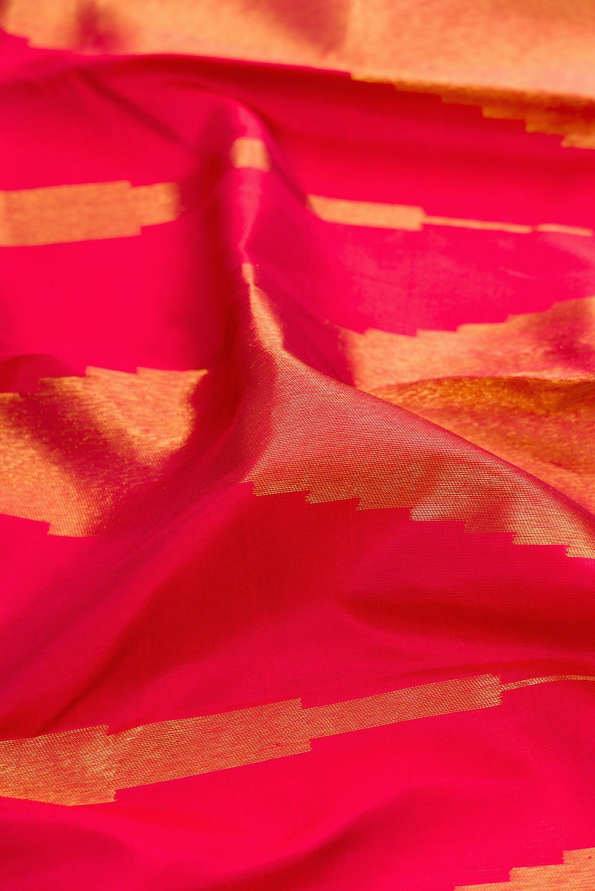 Close up of Maroon Kanjivaram Silk Saree with Zari Butta on the body and Without Border.  displaying folds