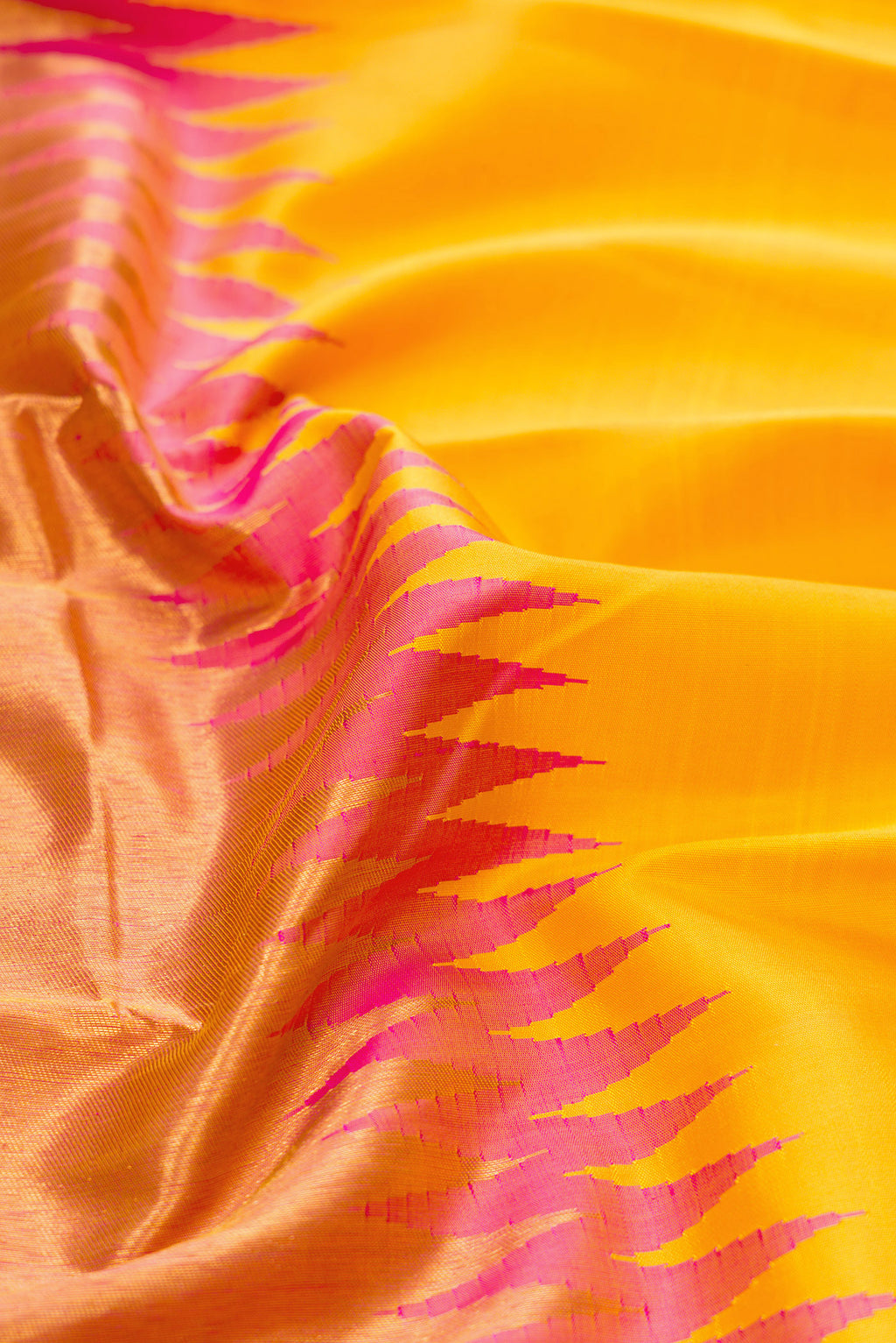 Close up of Yellow Kanjivaram Silk Saree with Plain Body and Rising Temple Border.  displaying folds
