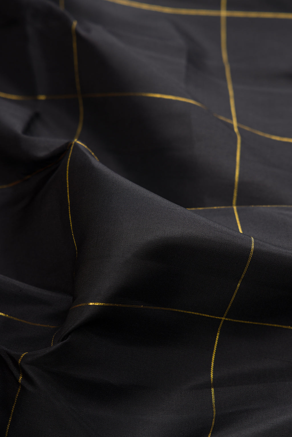 Close up of Pure Silk Black Kanchipuram Saree with Checked design on the body and Temple Border.  displaying folds