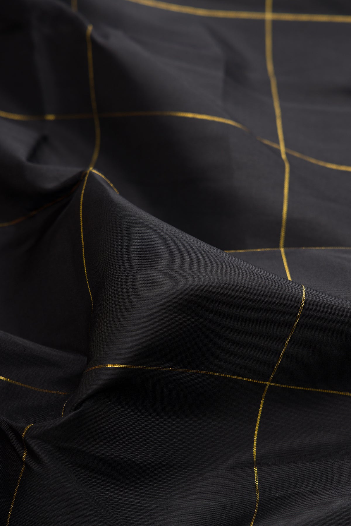 Close up of Pure Silk Black Kanchipuram Saree with Checked design on the body and Temple Border.  displaying folds