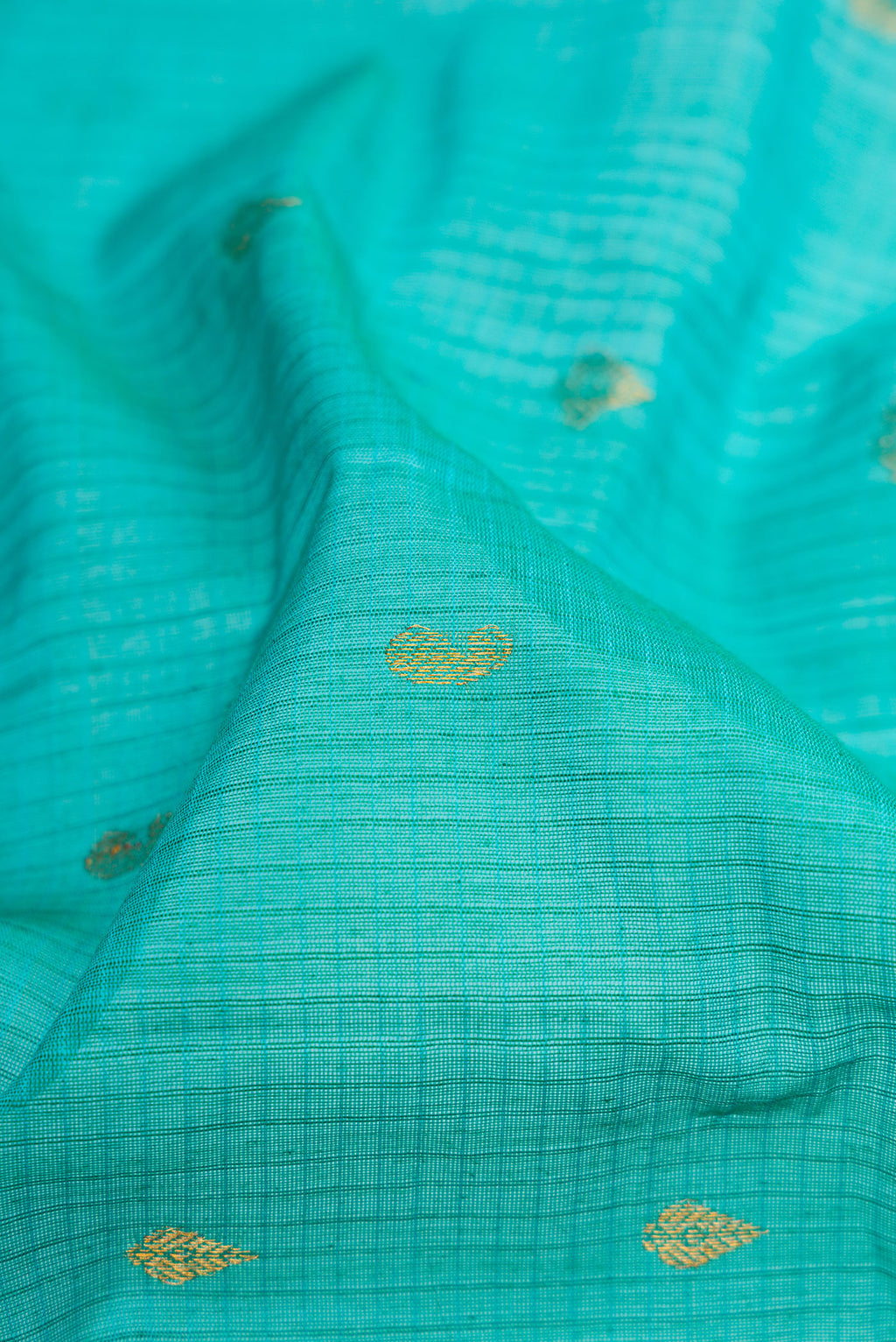 Close up of Sky Blue Gadwal Silk Cotton Saree with Checked design on the body and Zari Border.  displaying folds