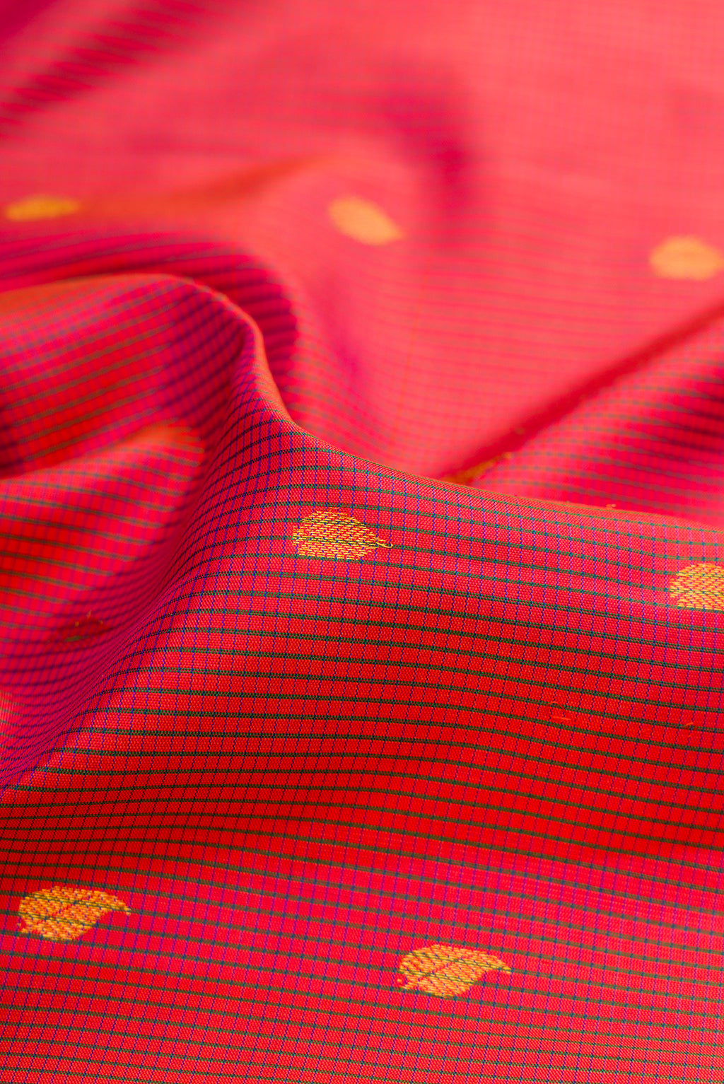 Close up of Coral Gadwal Silk Saree with Checked design on the body and Zari Border.  displaying folds