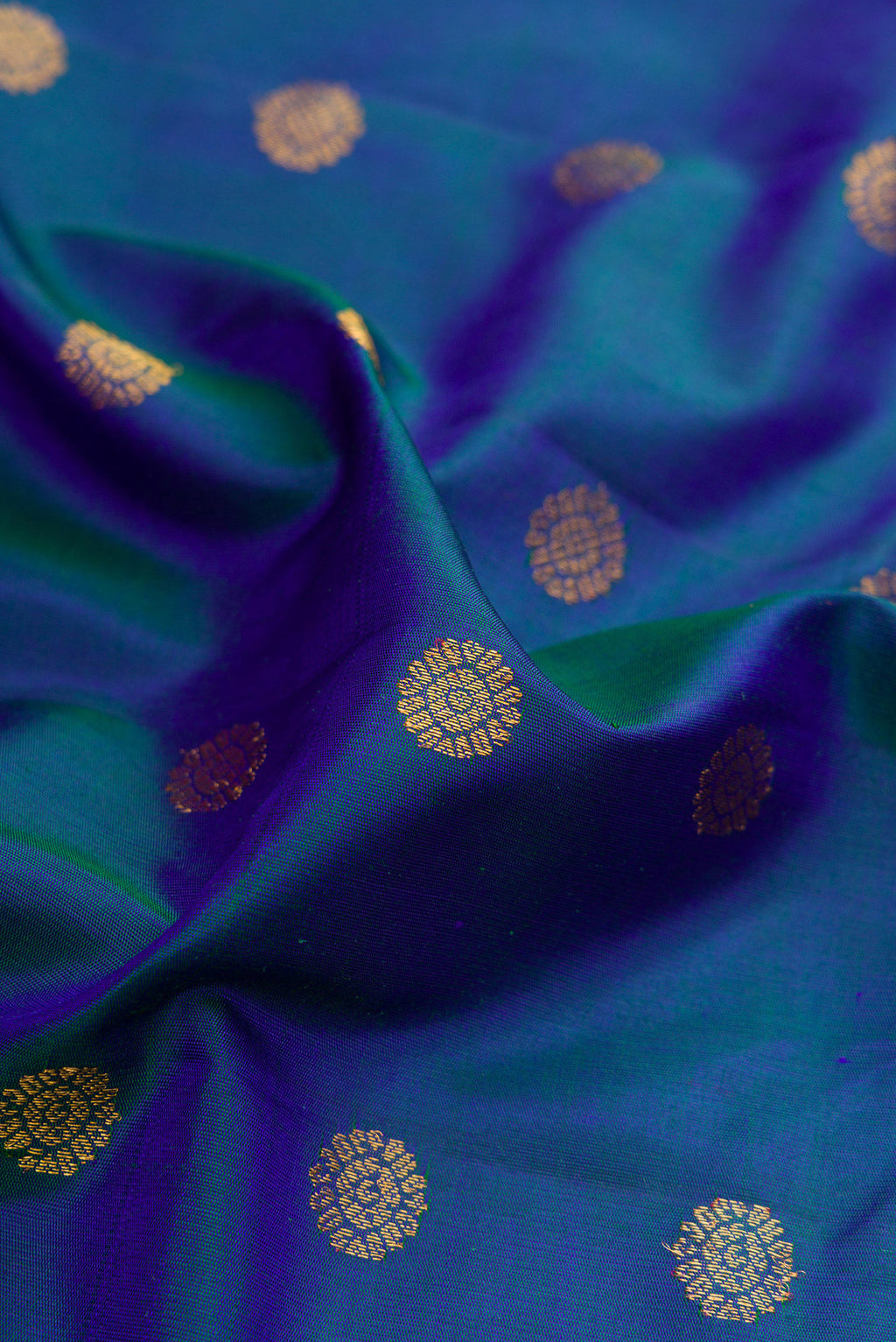 Close up of Peacock Blue Dual Tone Gadwal Silk Saree with Zari Butta on the body and Paithani Border.  displaying folds