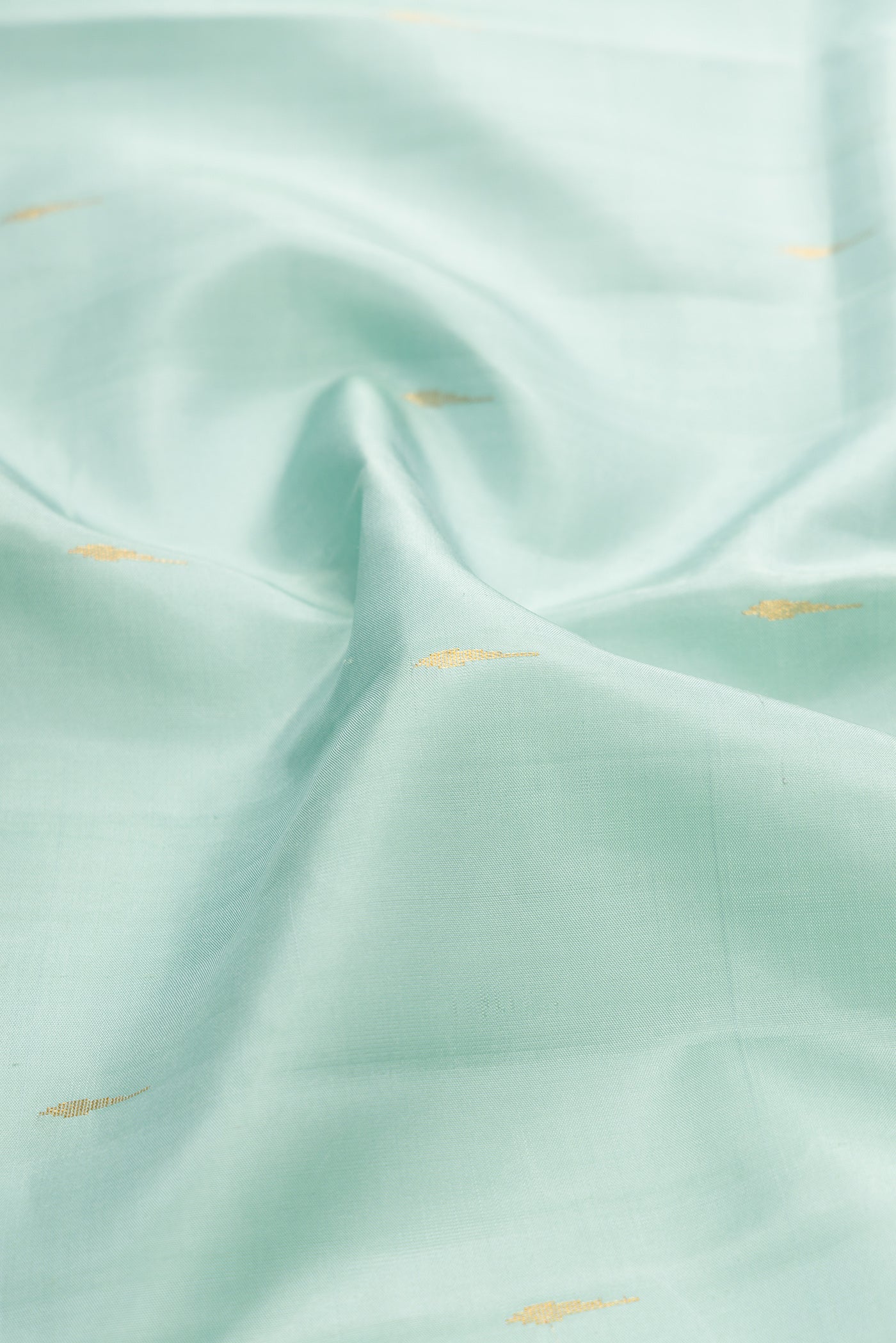 Close up of Light Blue Kanjivaram Silk Saree with Zari Butta on the body and Zari Border.  displaying folds