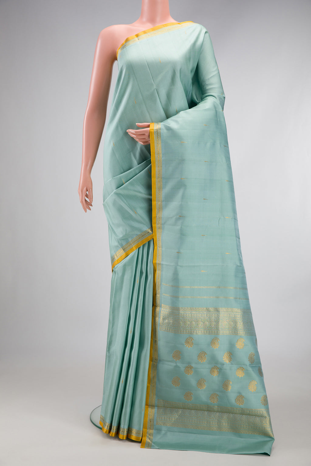 Light Blue Kanjivaram Silk Saree with Zari Butta on the body and Zari Border.  displayed on a mannequin