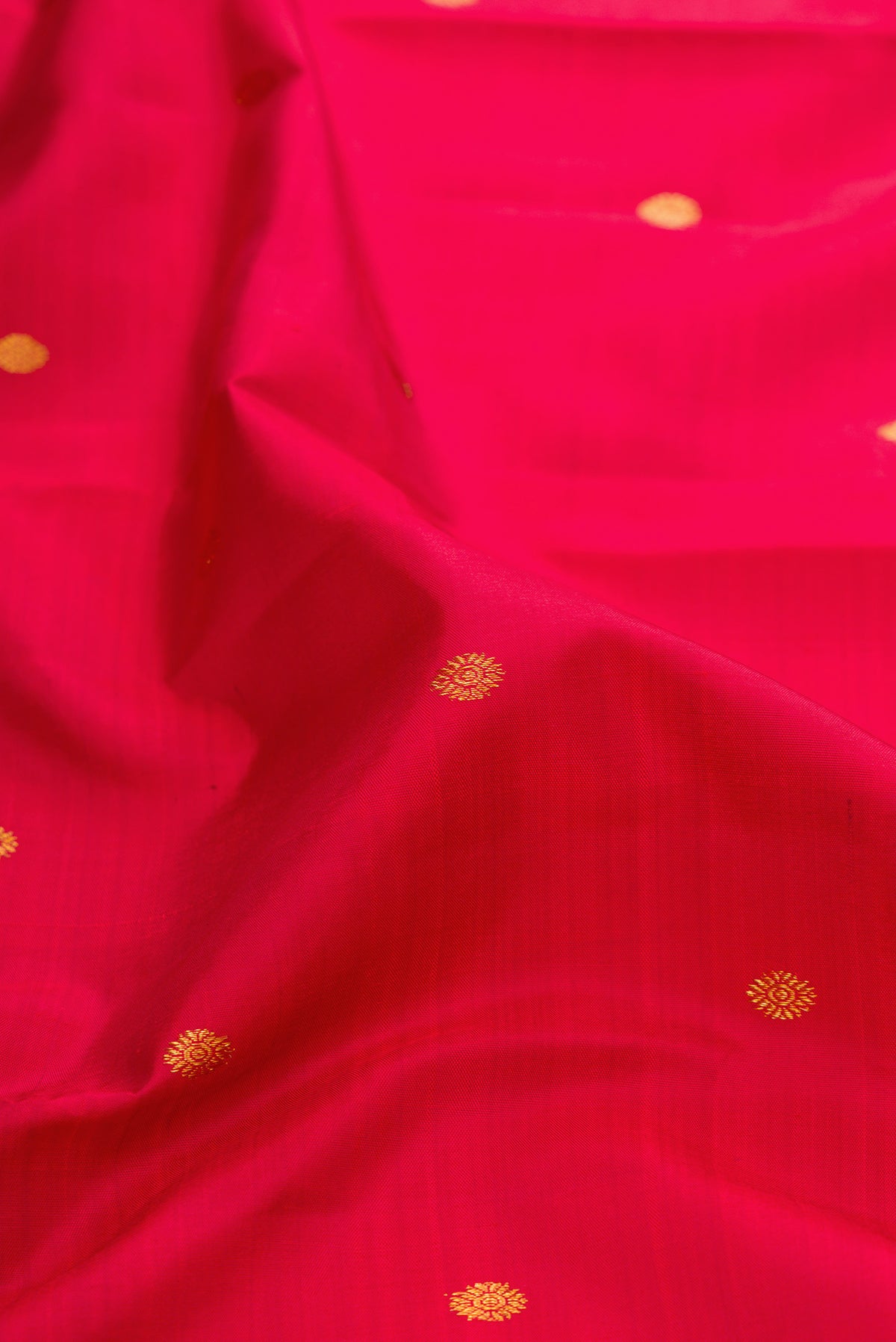 Close up of Maroon Kanjivaram Silk Saree with Zari Butta on the body and Zari Border.  displaying folds