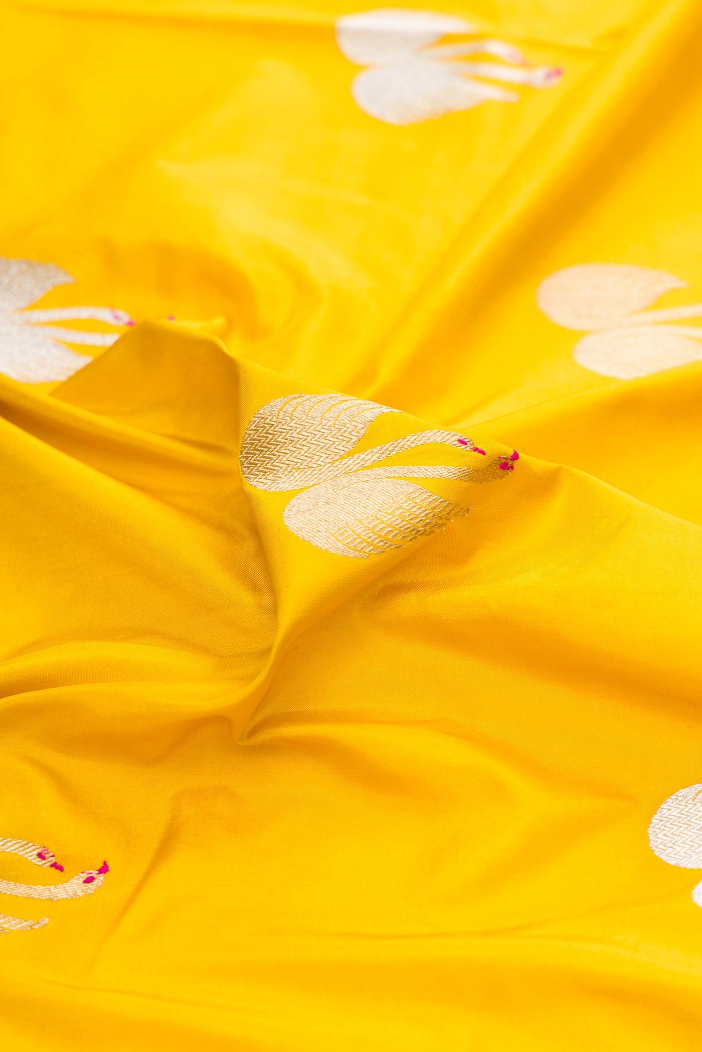 Close up of Yellow Dual Tone Banarasi Silk Saree with Zari And Thread Butta on the body and Zari Border.  displaying folds