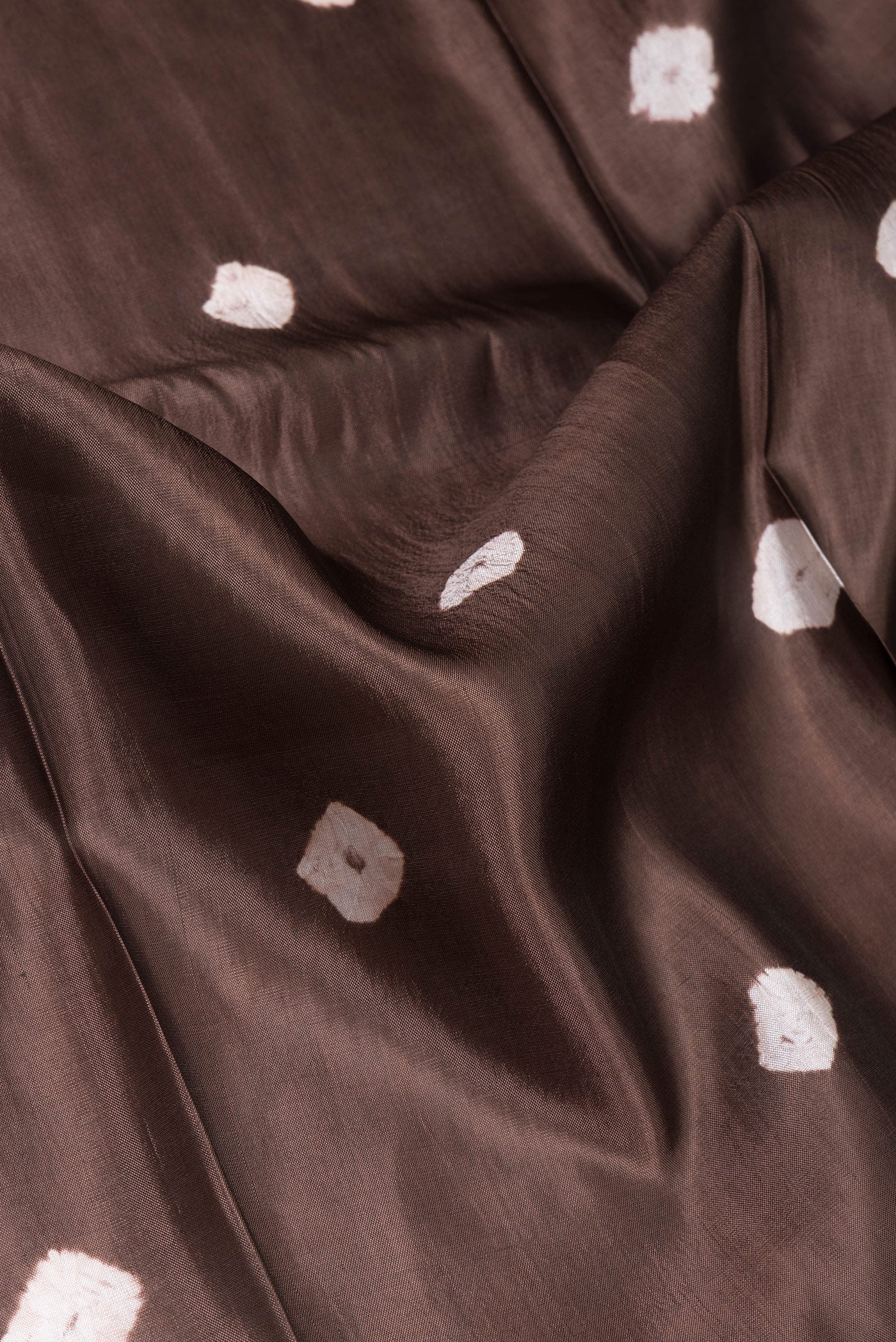 Close up of Brown Blended Tussar Silk Saree with Printed design on the body and Zari Border.  displaying folds