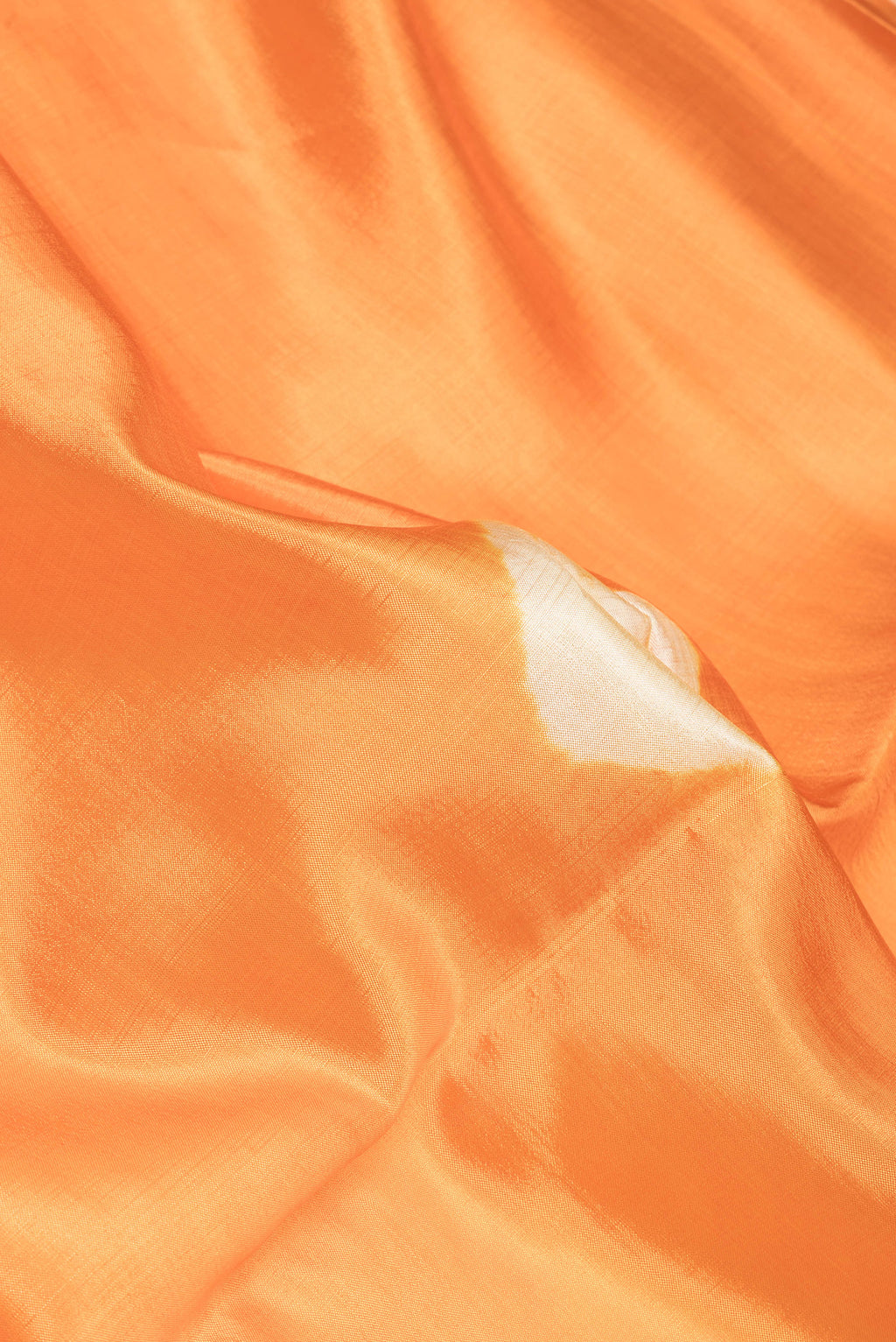 Close up of Orange Blended Tussar Silk Saree with Bandhani Print on the body and Zari Border.  displaying folds