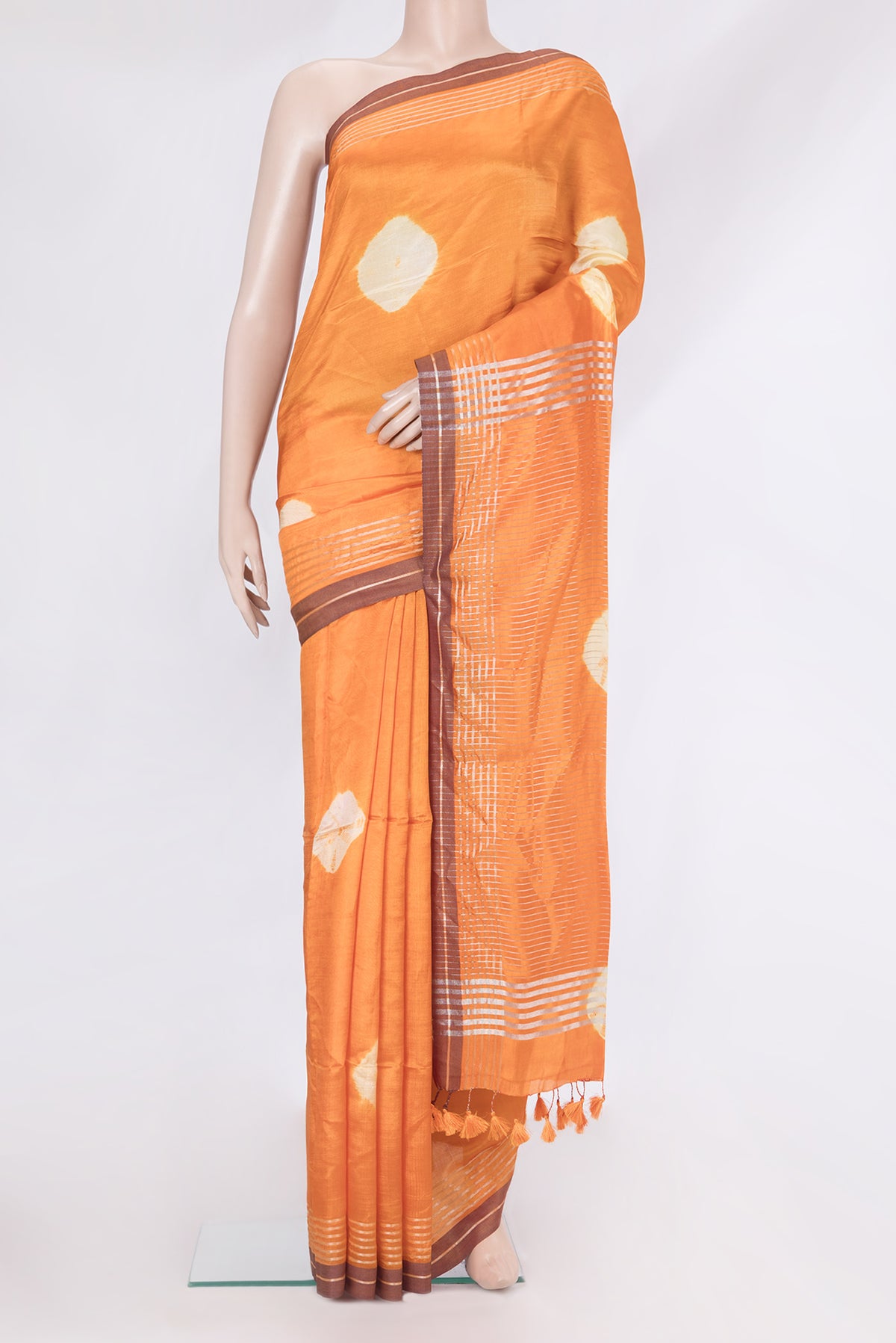 Orange Blended Tussar Silk Saree with Bandhani Print on the body and Zari Border.  displayed on a mannequin