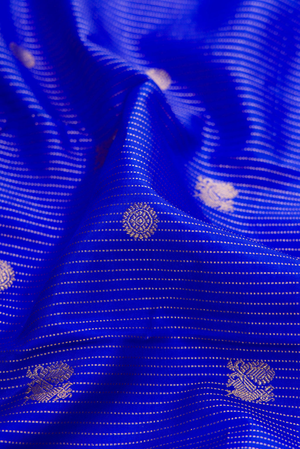 Close up of Royal Blue Kanchipuram Silk Saree with Stripes on the body and Zari Border.  displaying folds