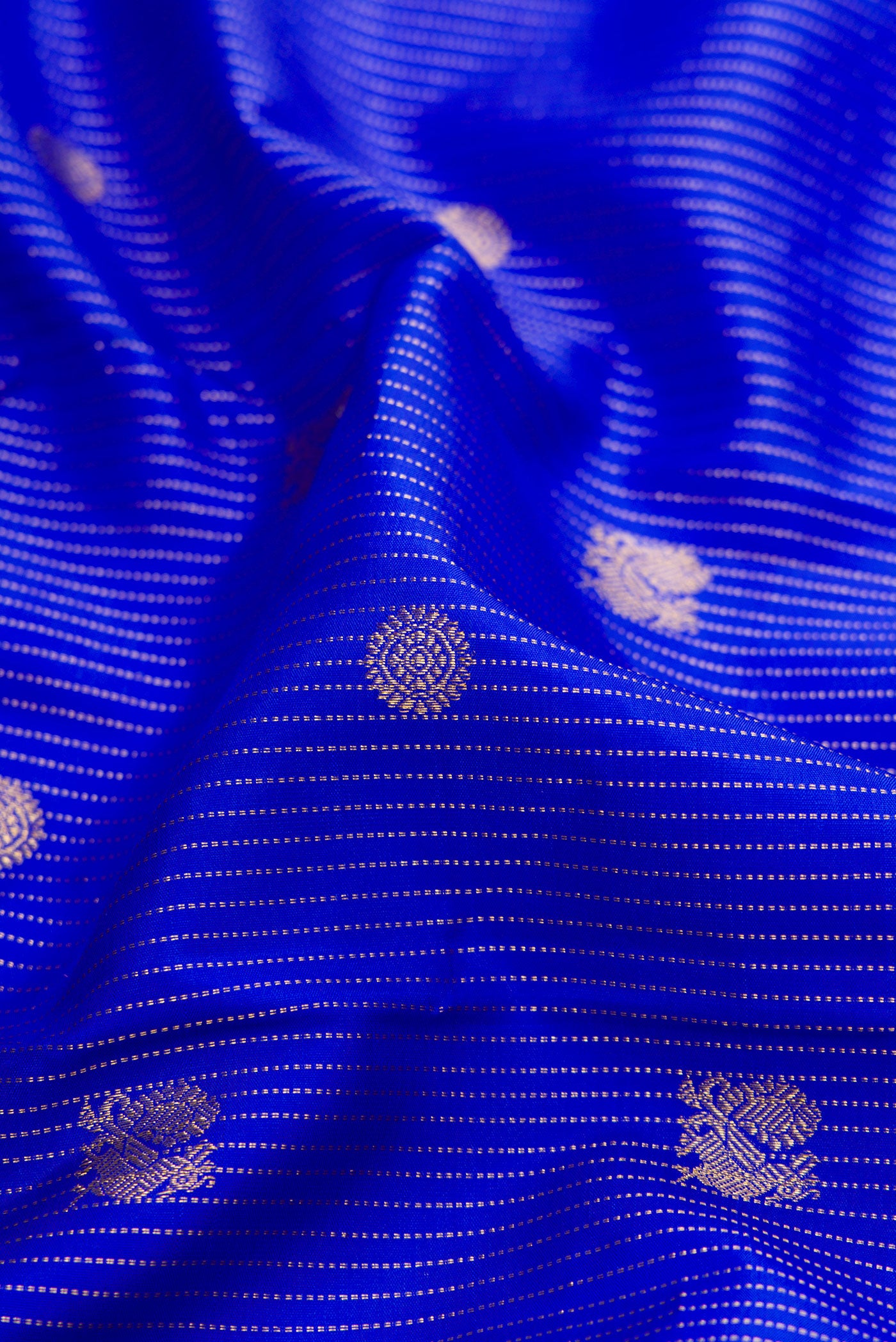 Close up of Royal Blue Kanchipuram Silk Saree with Stripes on the body and Zari Border.  displaying folds