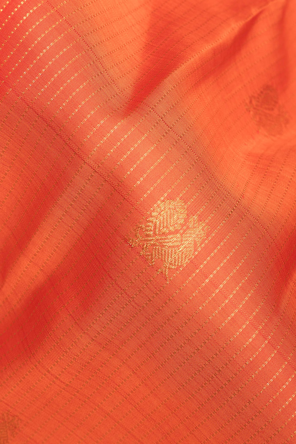 Close up of Pure Silk Orange Kanchipuram Saree with Stripes on the body and Zari Border.  displaying folds
