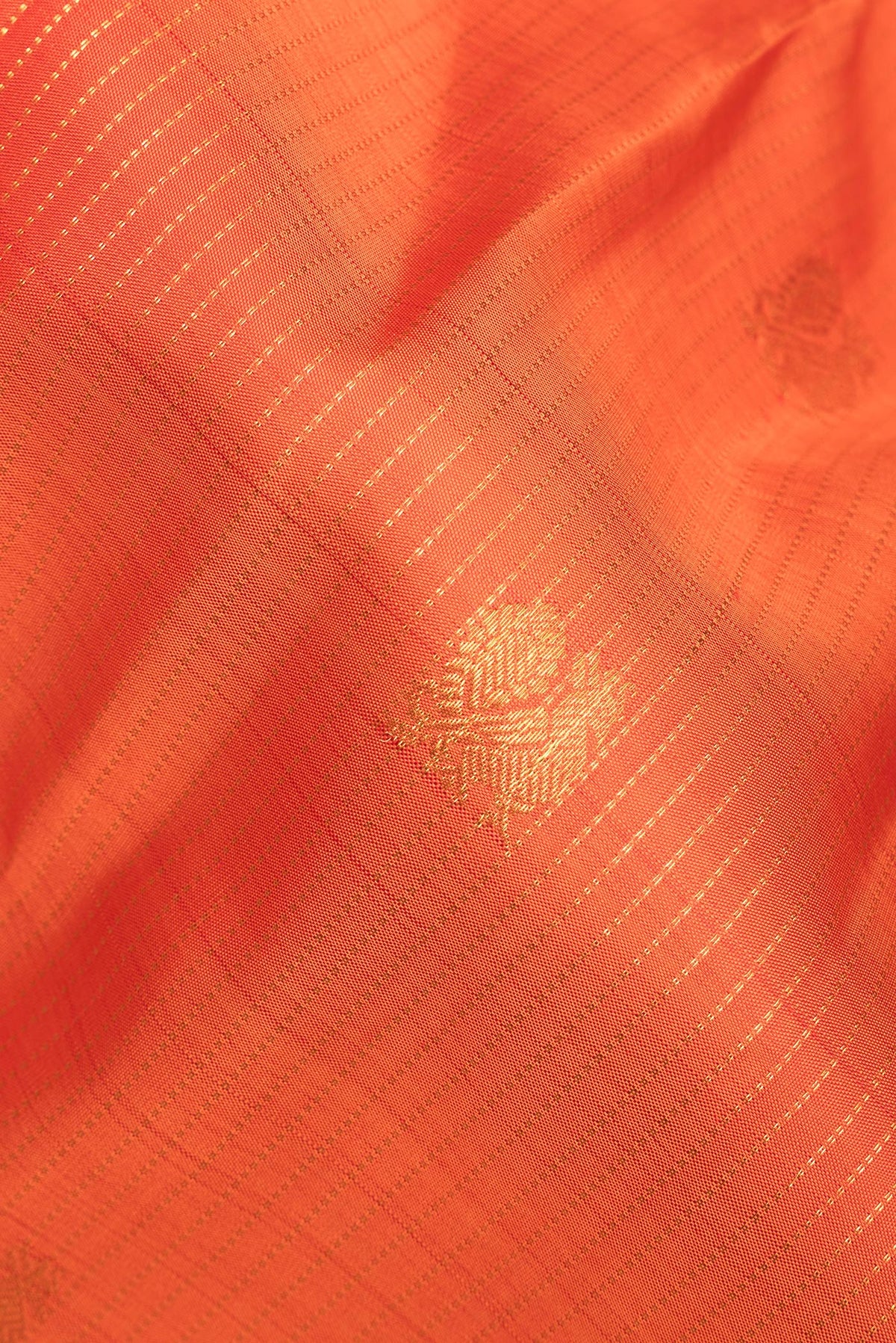 Close up of Pure Silk Orange Kanchipuram Saree with Stripes on the body and Zari Border.  displaying folds