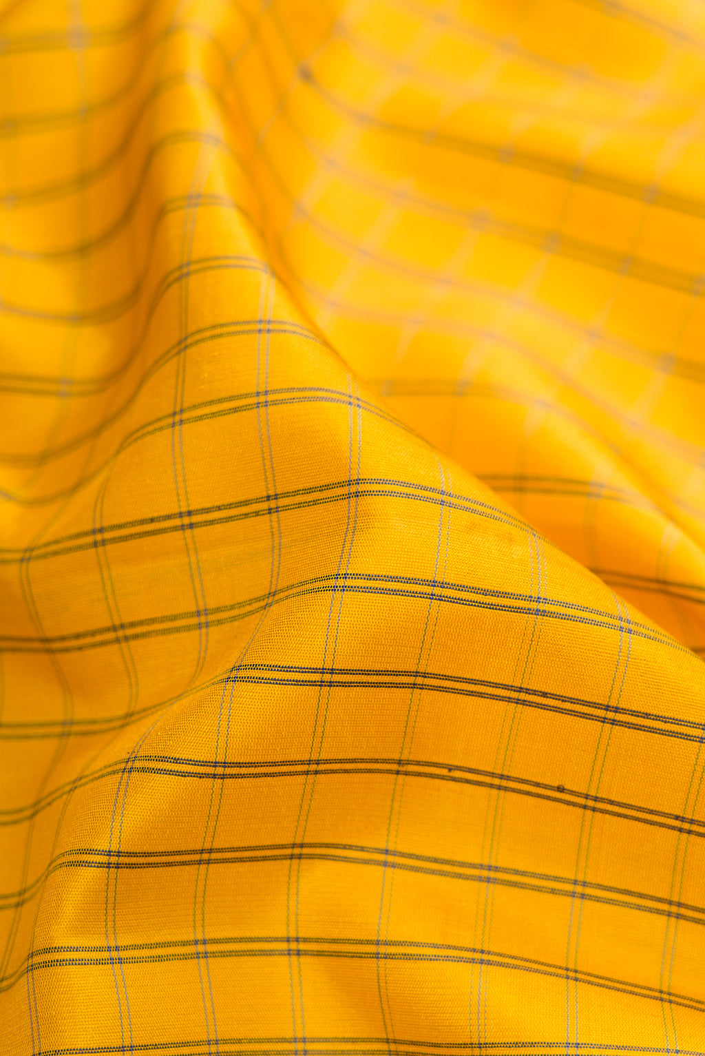 Close up of Yellow Gadwal Silk Saree with Checked design on the body and Temple Border.  displaying folds
