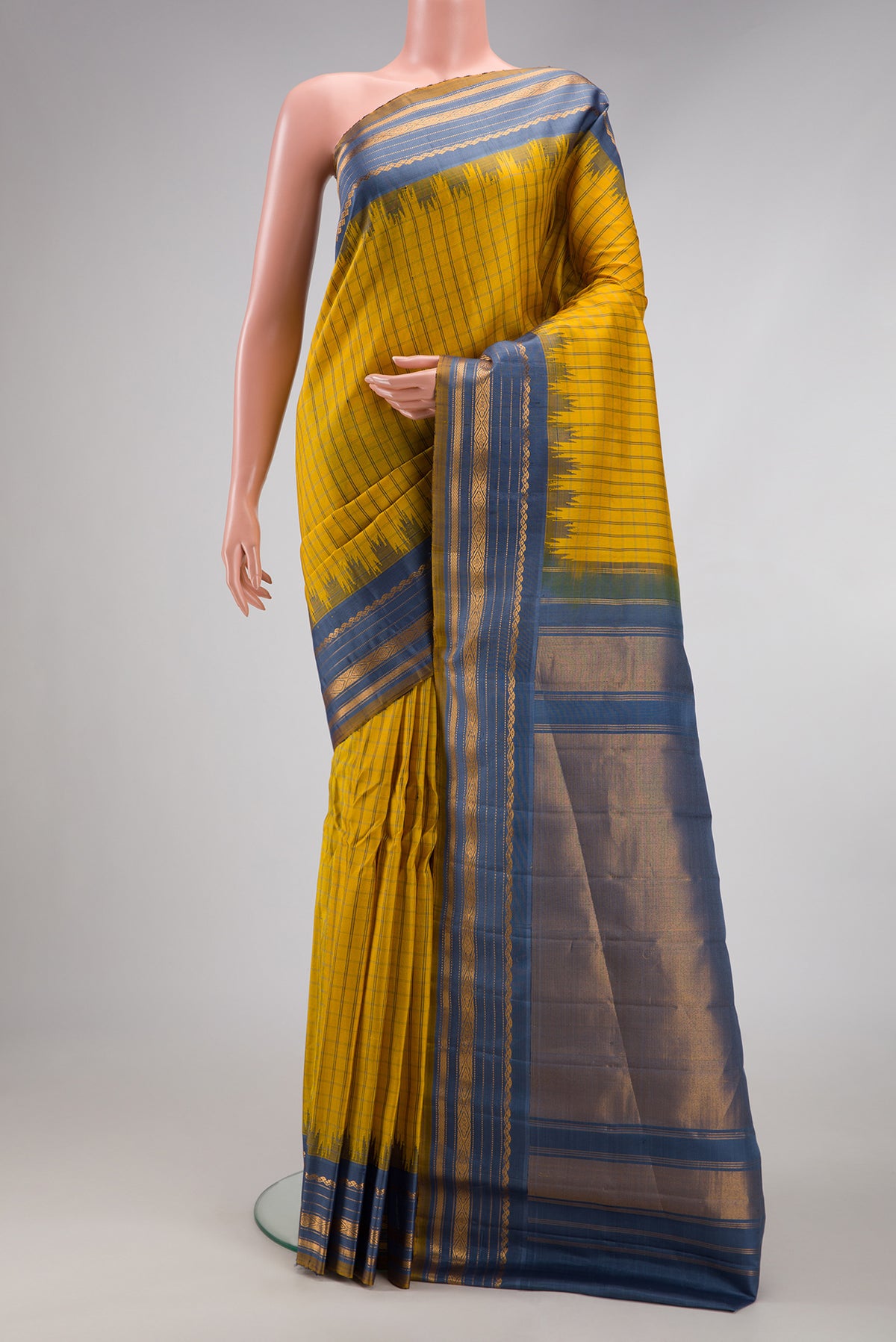 Yellow Gadwal Silk Saree with Checked design on the body and Temple Border.  displayed on a mannequin