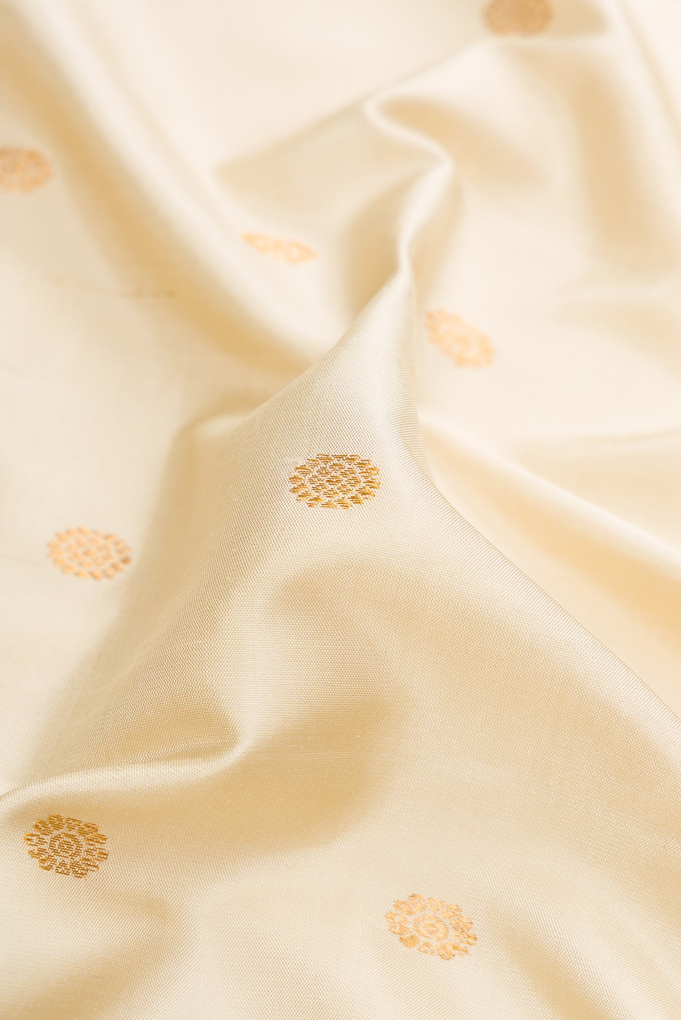 Close up of Off White Gadwal Silk Saree with Zari Butta on the body and Temple Border.  displaying folds