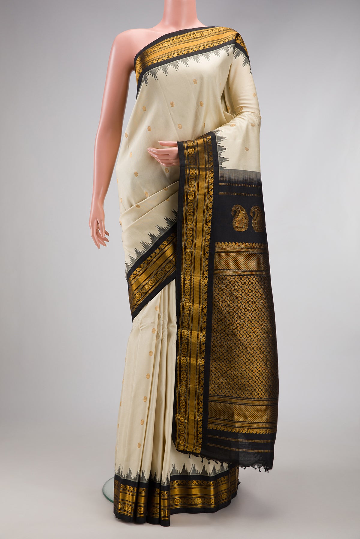 Off White Gadwal Silk Saree with Zari Butta on the body and Temple Border.  displayed on a mannequin