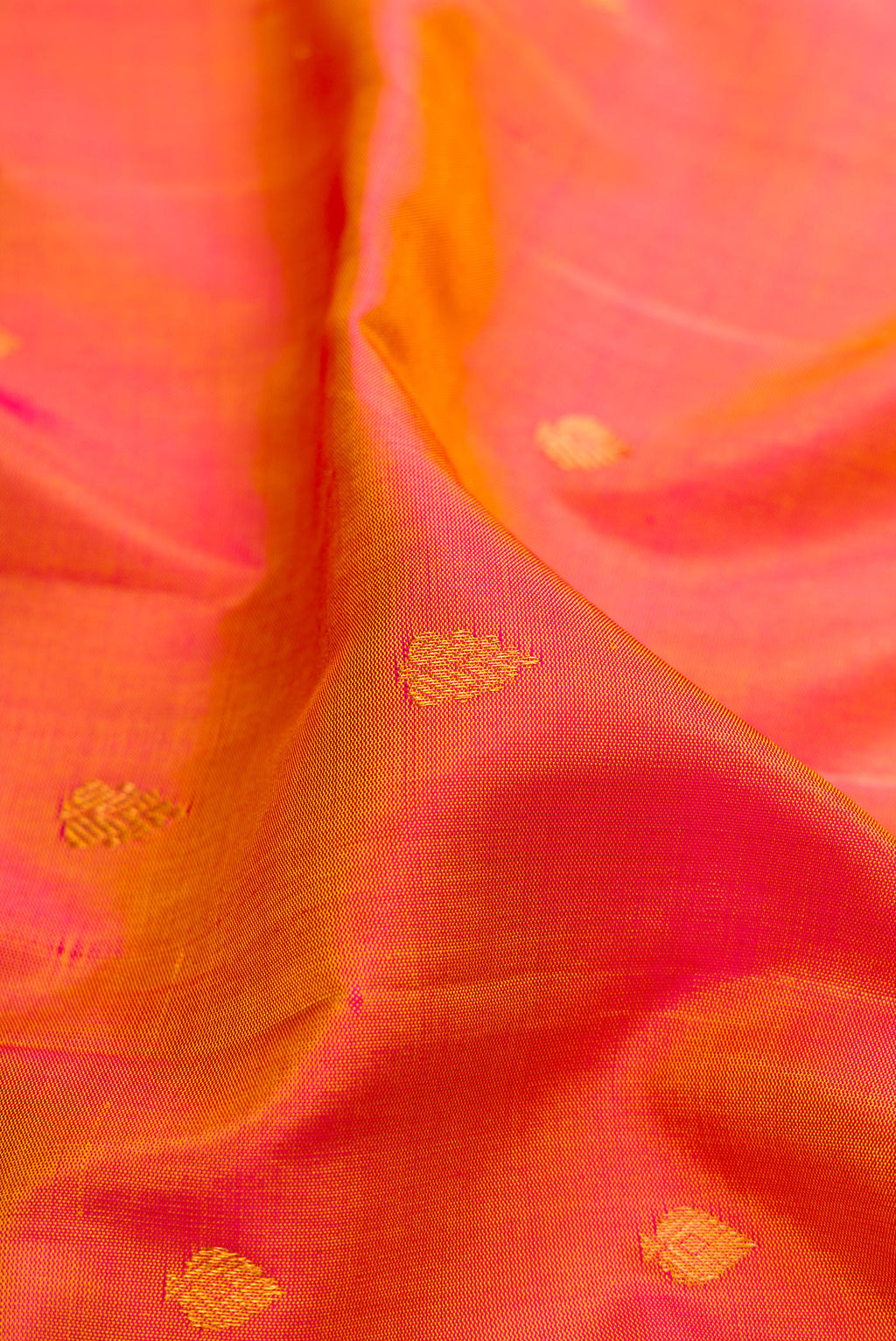 Close up of Pinkish Yellow Dual Tone Gadwal Silk Saree with Zari Butta on the body and Fancy Border.  displaying folds