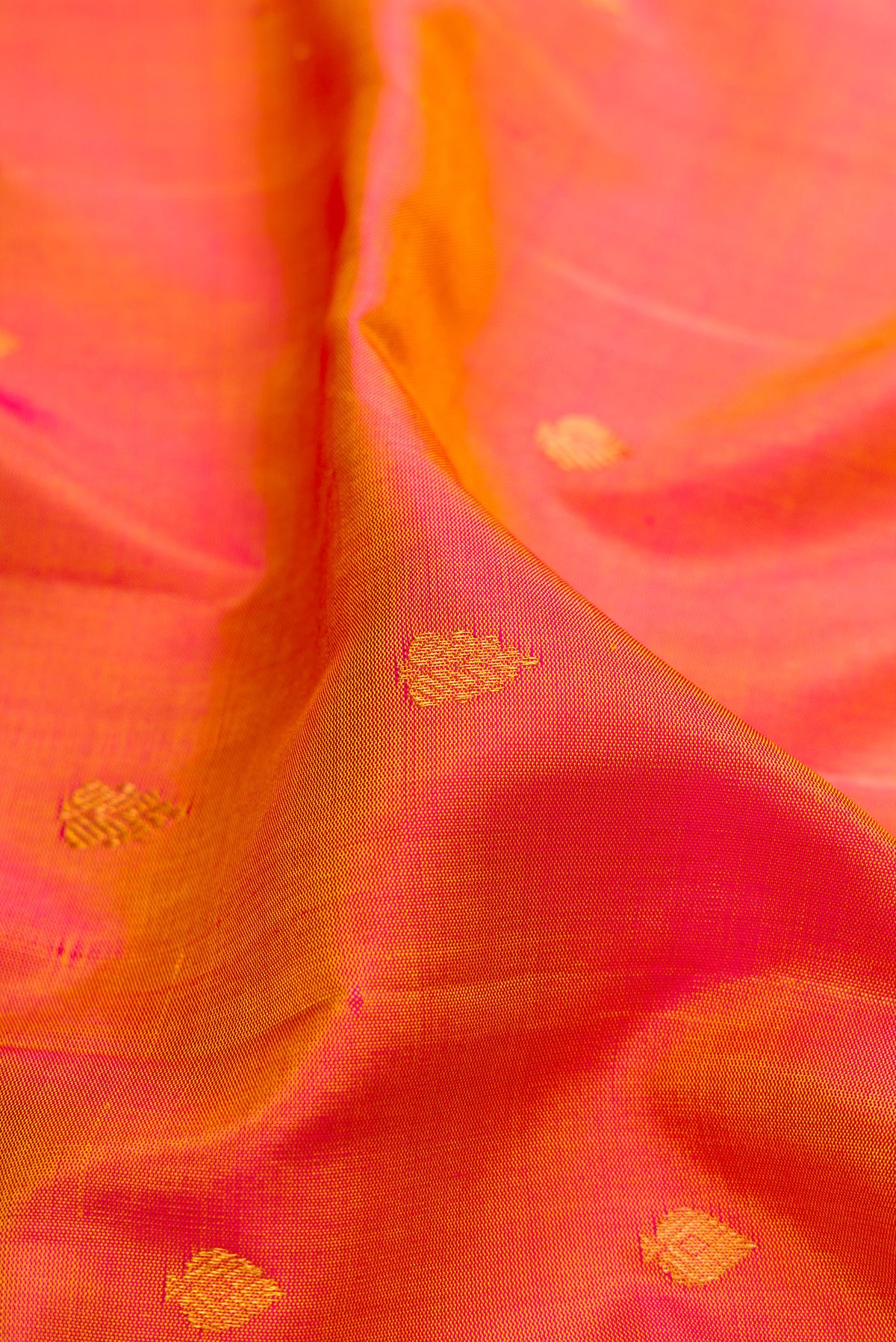 Close up of Pinkish Yellow Dual Tone Gadwal Silk Saree with Zari Butta on the body and Fancy Border.  displaying folds
