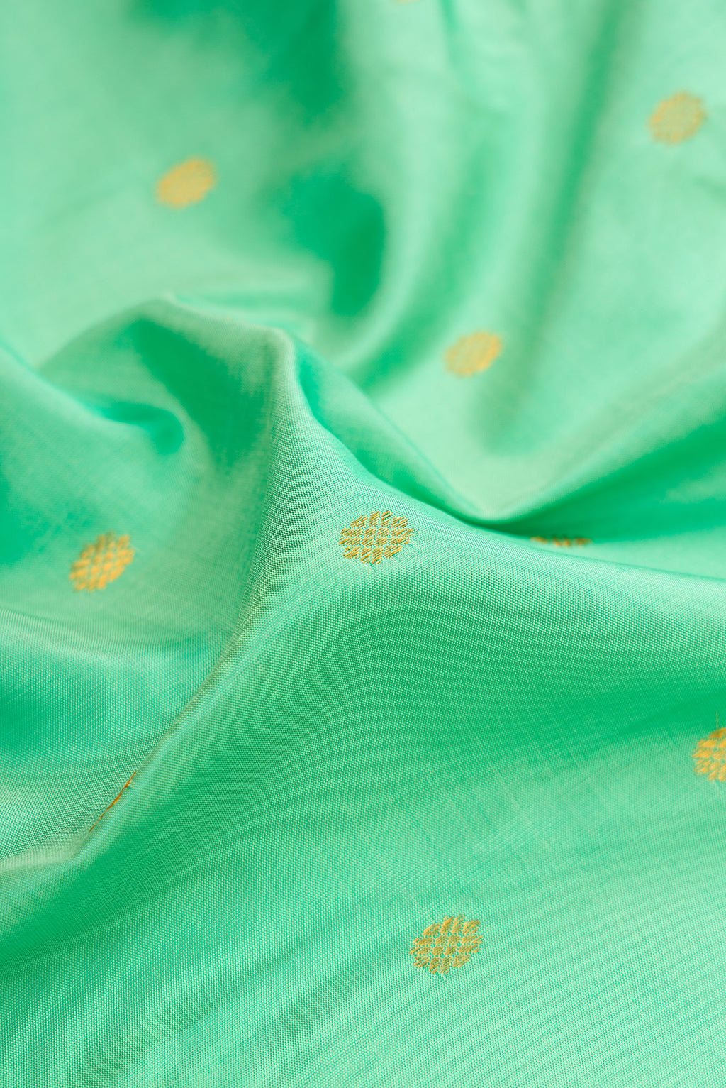 Close up of Sea Green Gadwal Silk Saree with Zari Butta on the body and Zari Border.  displaying folds