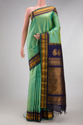 Pista Green Gadwal Silk Saree with Zari Butta on the body and Temple Border.  displayed on a mannequin