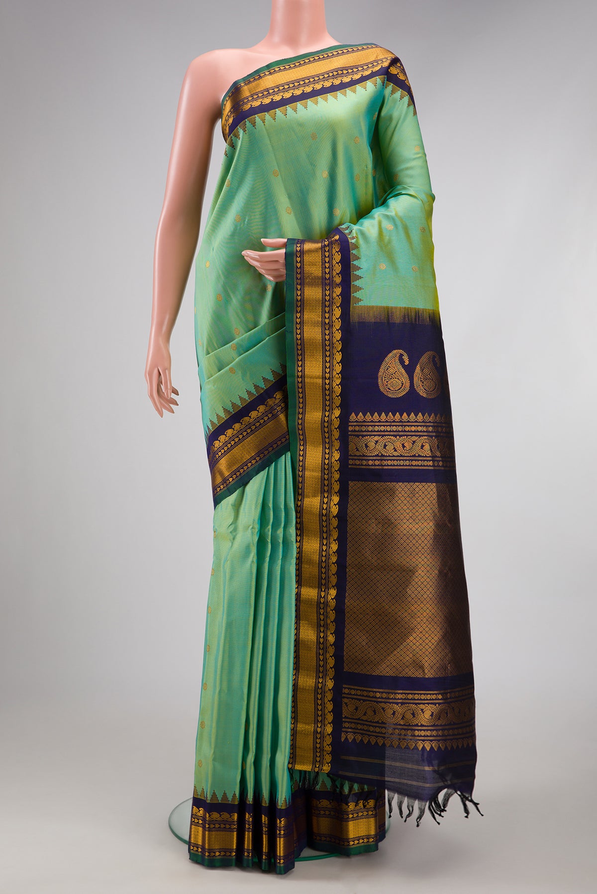 Pista Green Gadwal Silk Saree with Zari Butta on the body and Temple Border.  displayed on a mannequin
