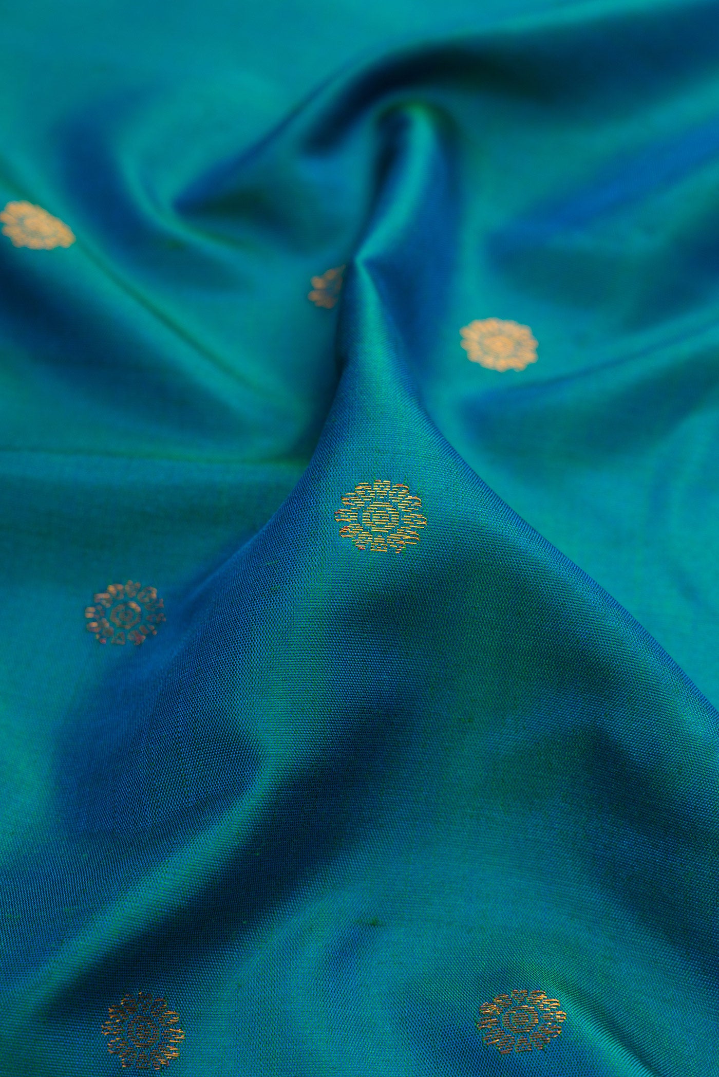 Close up of Peacock Blue Gadwal Silk Saree with Zari Butta on the body and Zari Border.  displaying folds