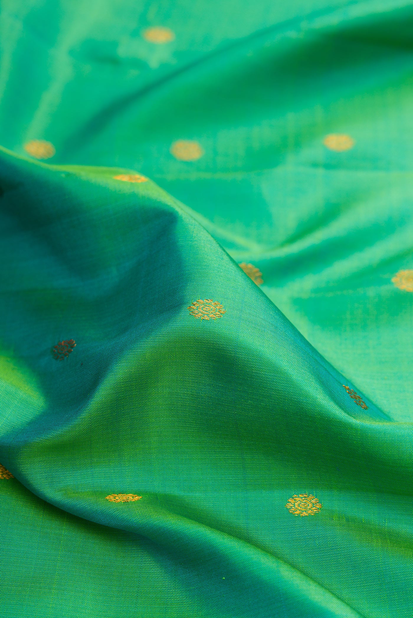 Close up of Sea Green Gadwal Silk Saree with Zari Butta on the body and Zari Border.  displaying folds