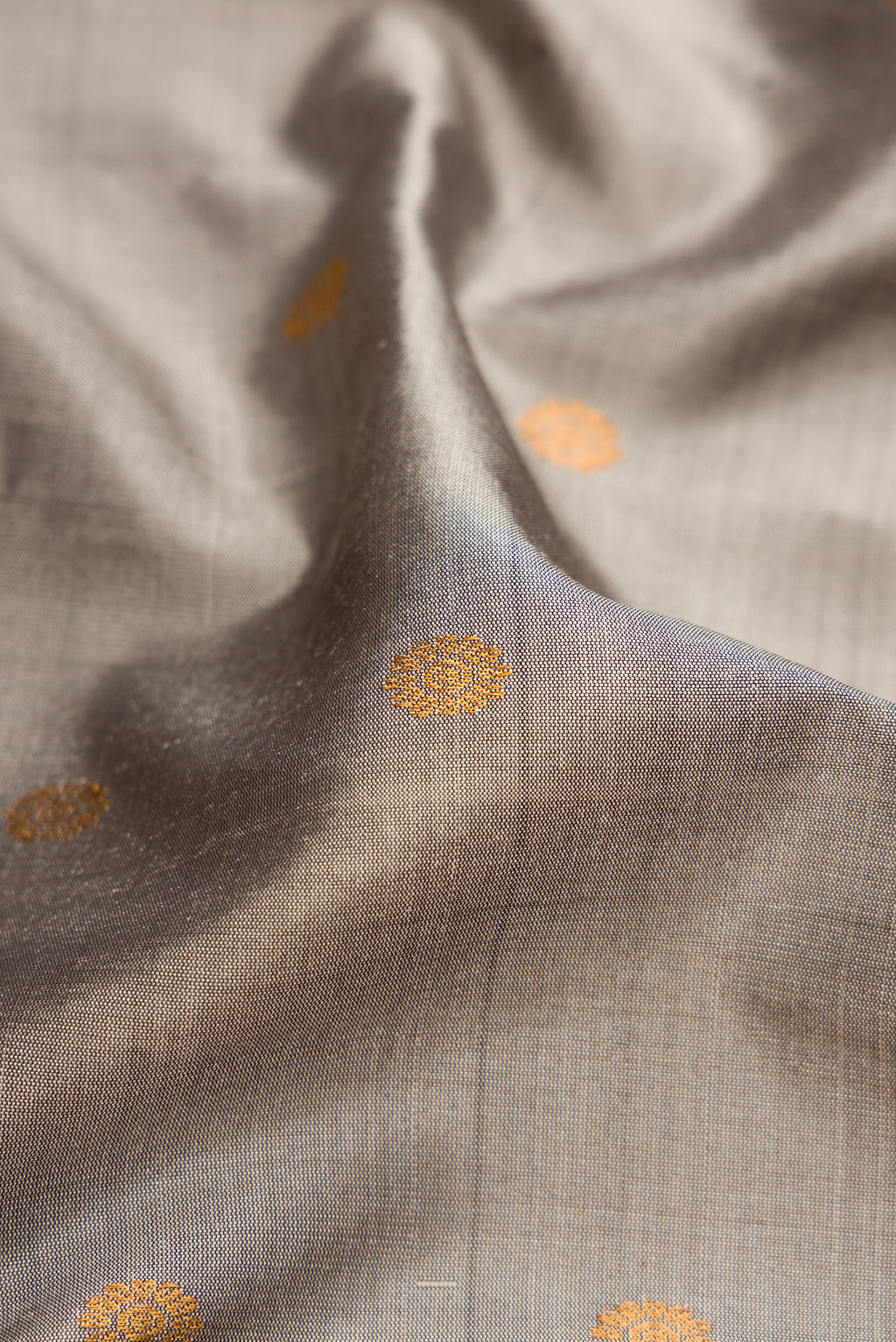 Close up of Grey Gadwal Silk Saree with Zari Butta on the body and Temple Border.  displaying folds