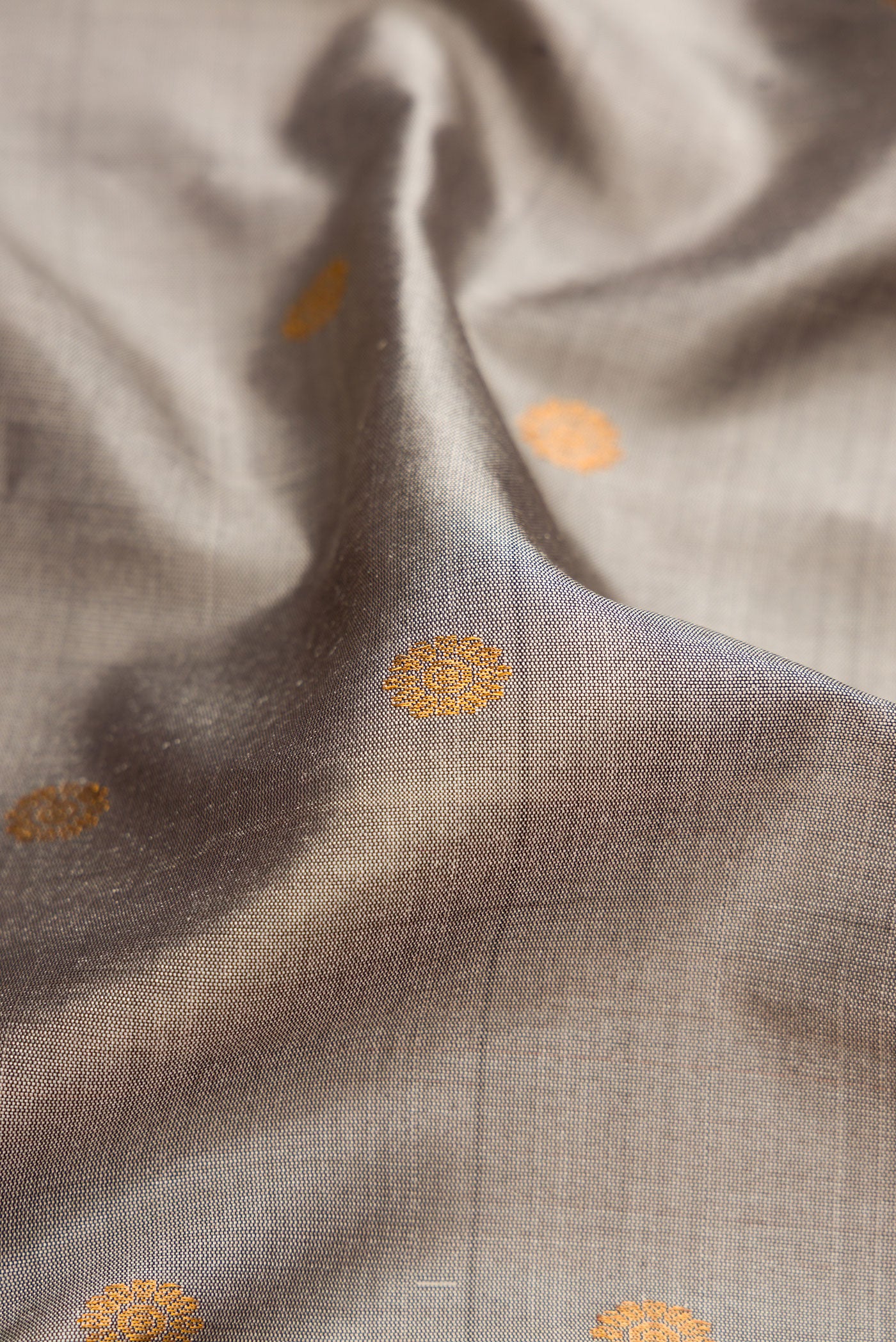 Close up of Grey Gadwal Silk Saree with Zari Butta on the body and Temple Border.  displaying folds