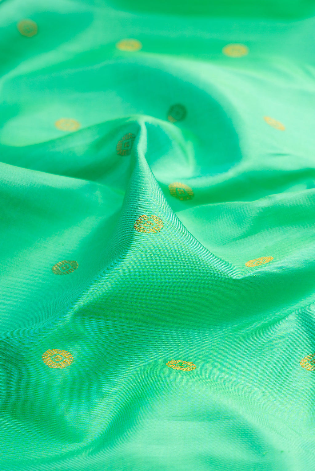 Close up of Sea Green Gadwal Silk Saree with Zari Butta on the body and Zari Border.  displaying folds