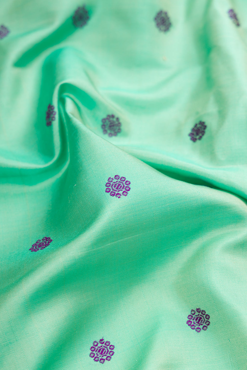 Close up of Sea Green Gadwal Silk Saree with Thread Butta on the body and Temple Border.  displaying folds