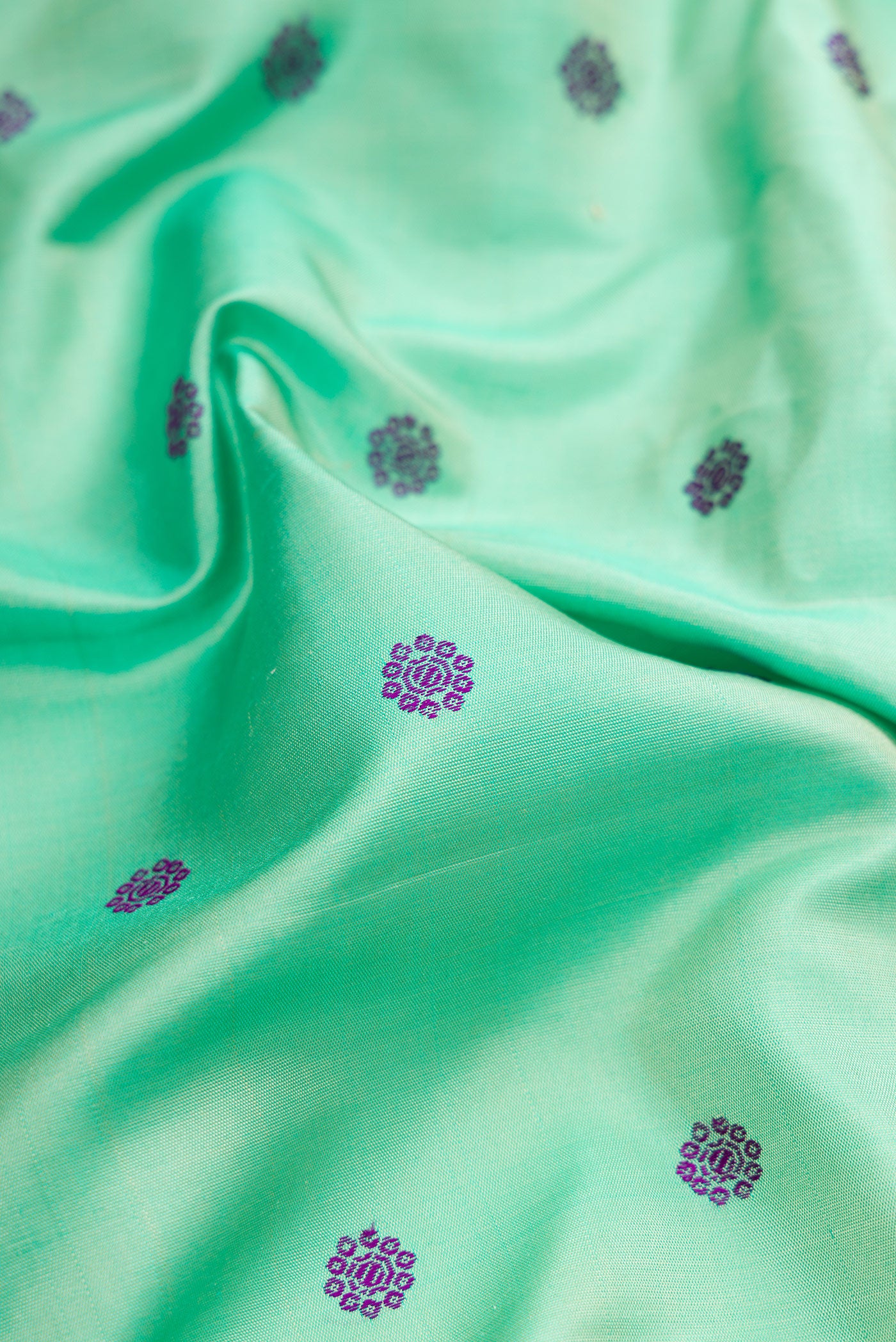 Close up of Sea Green Gadwal Silk Saree with Thread Butta on the body and Temple Border.  displaying folds
