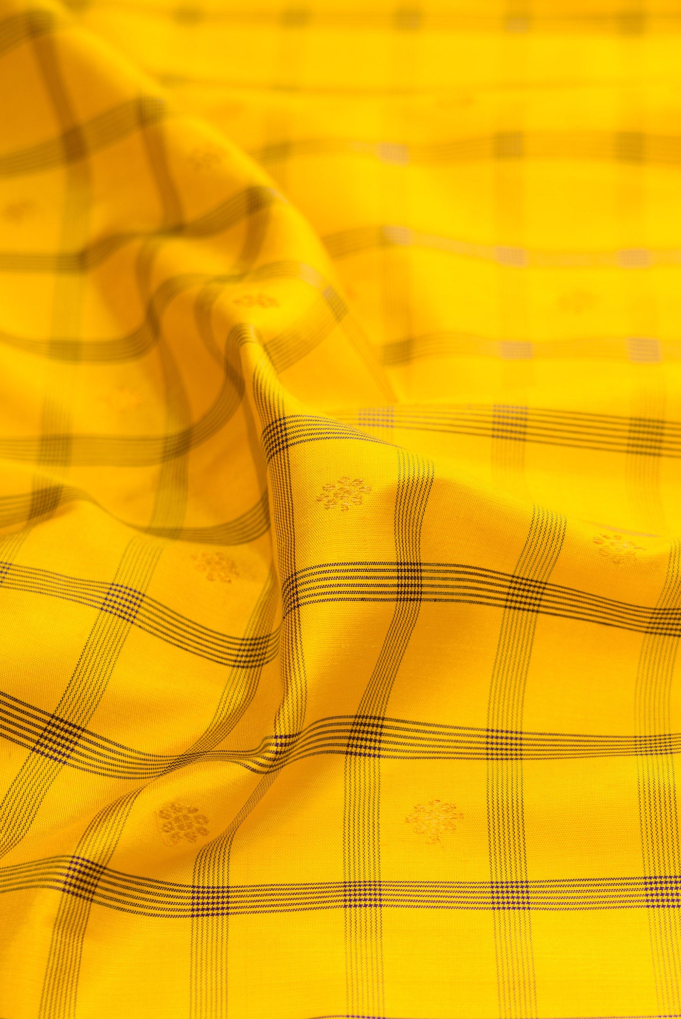 Close up of Yellow Gadwal Silk Saree with Checked design on the body and Zari Border.  displaying folds