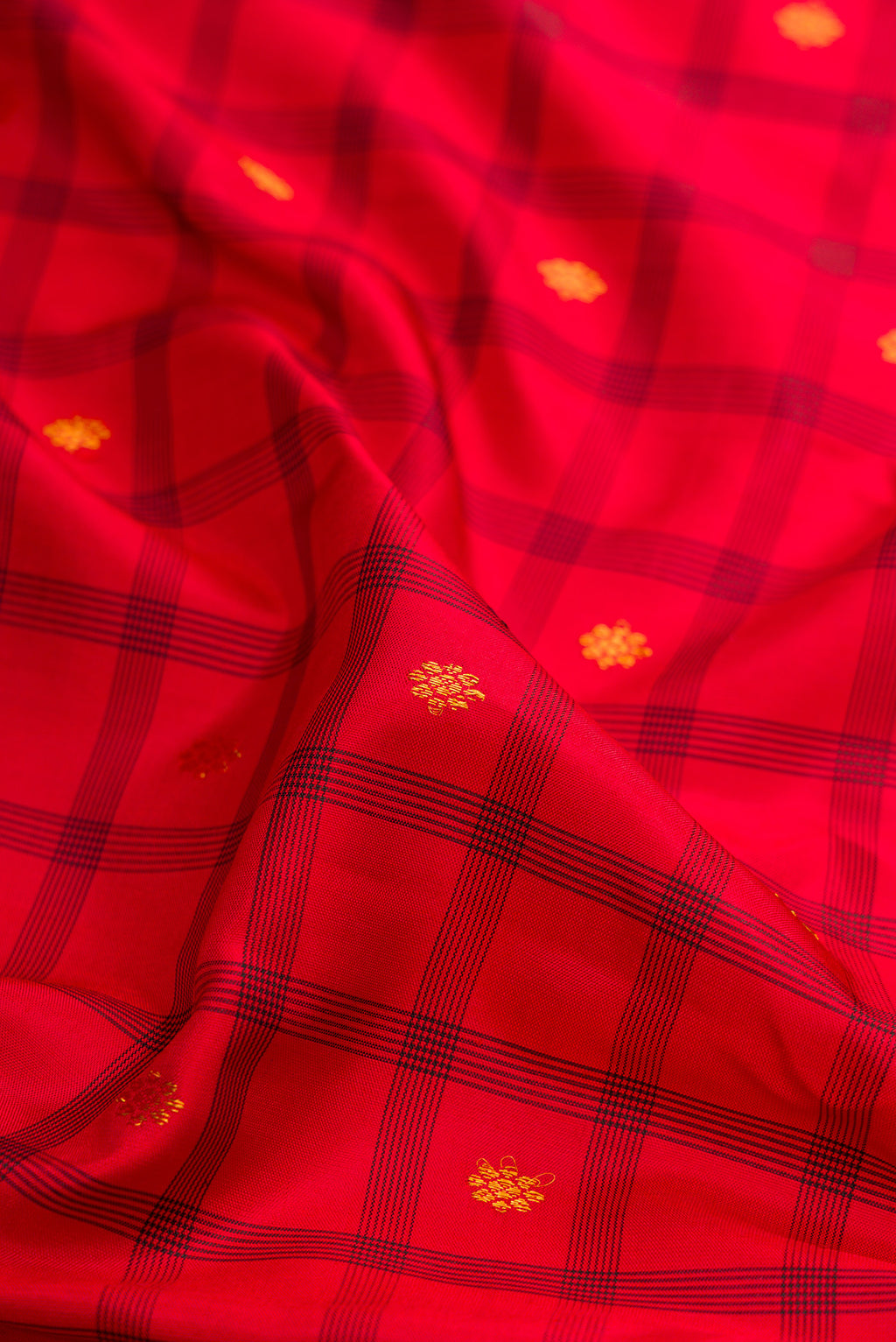 Close up of Red Gadwal Silk Saree with Checked design on the body and Zari Border.  displaying folds