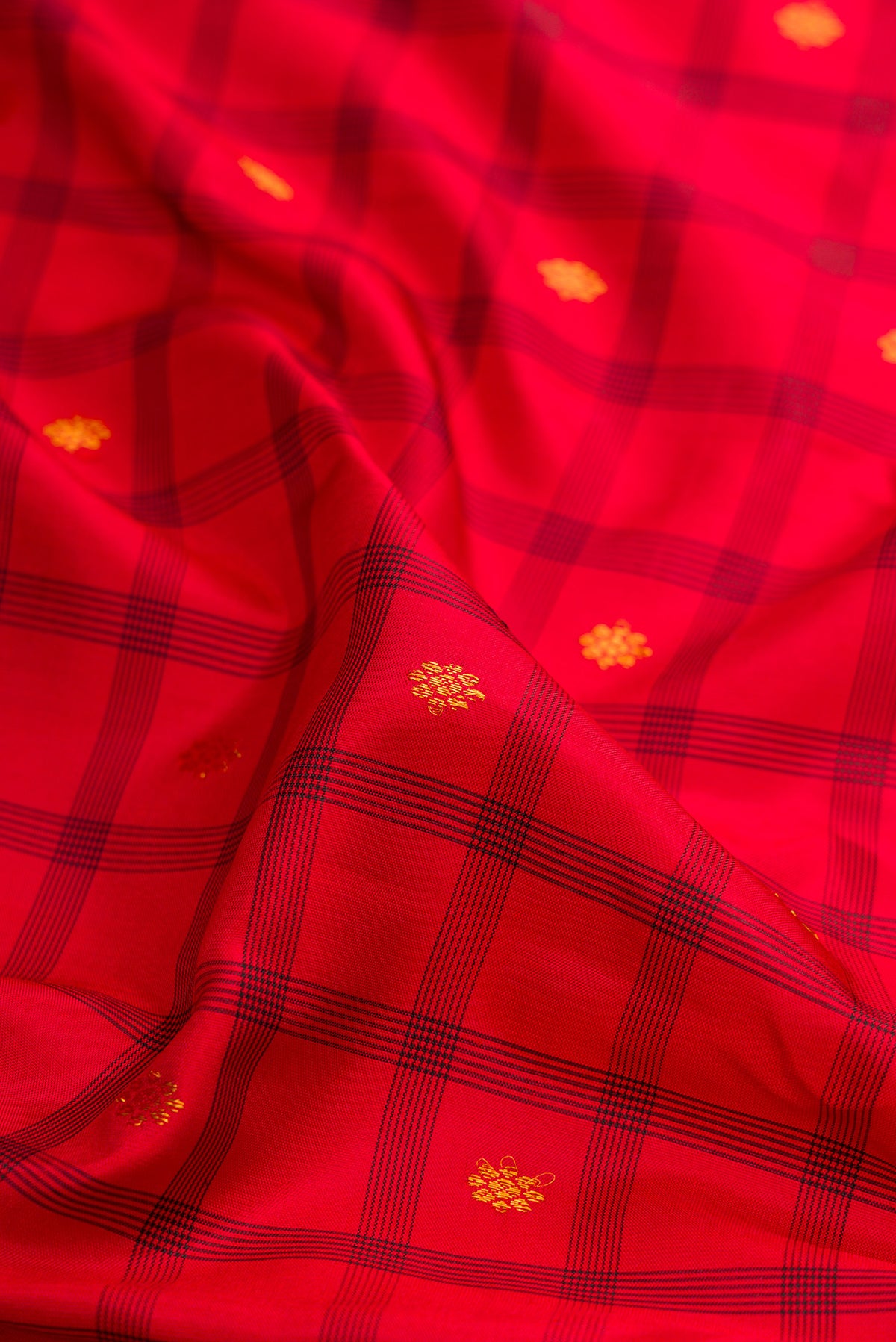 Close up of Red Gadwal Silk Saree with Checked design on the body and Zari Border.  displaying folds