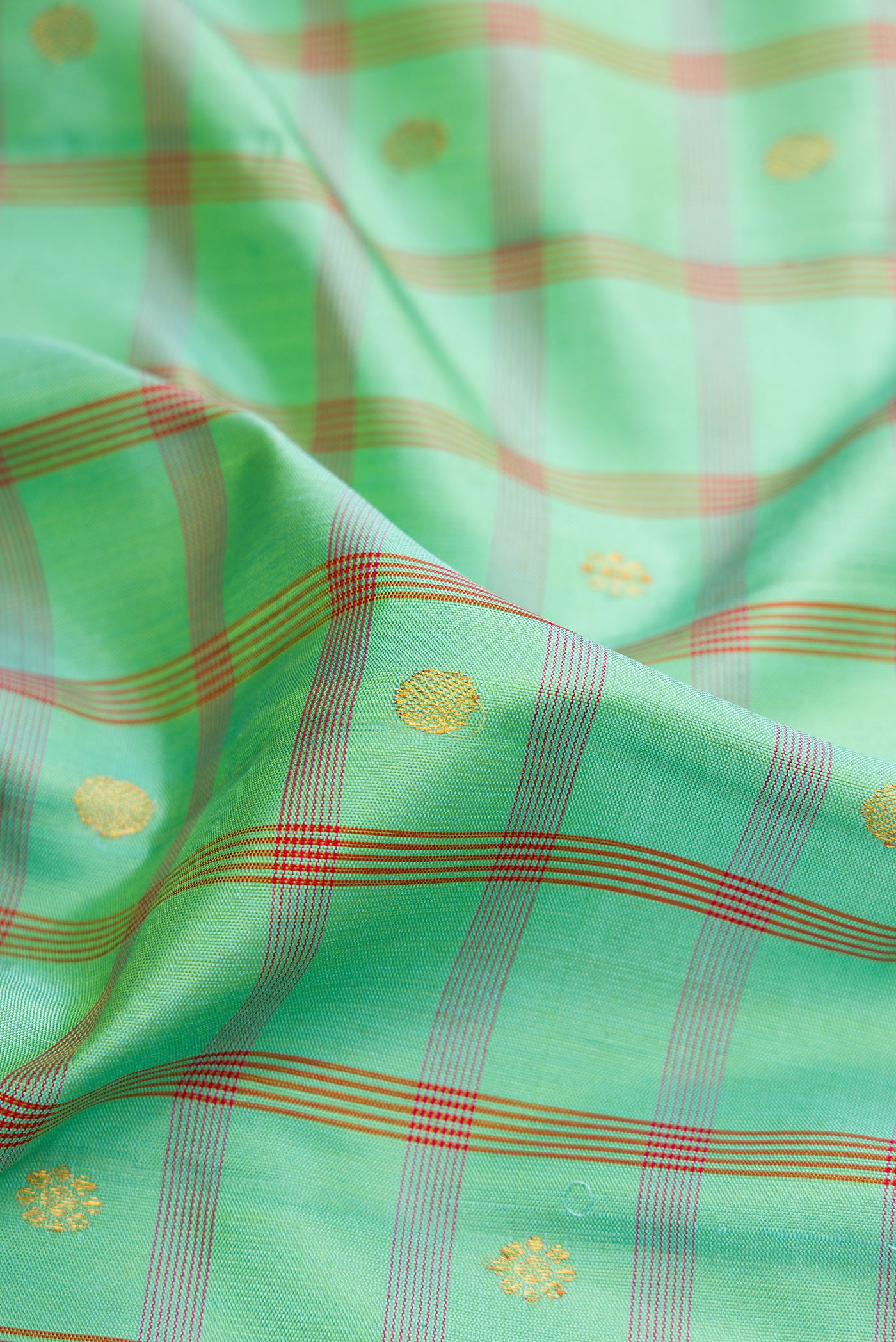 Close up of Sea Green Gadwal Silk Saree with Checked design on the body and Zari Border.  displaying folds