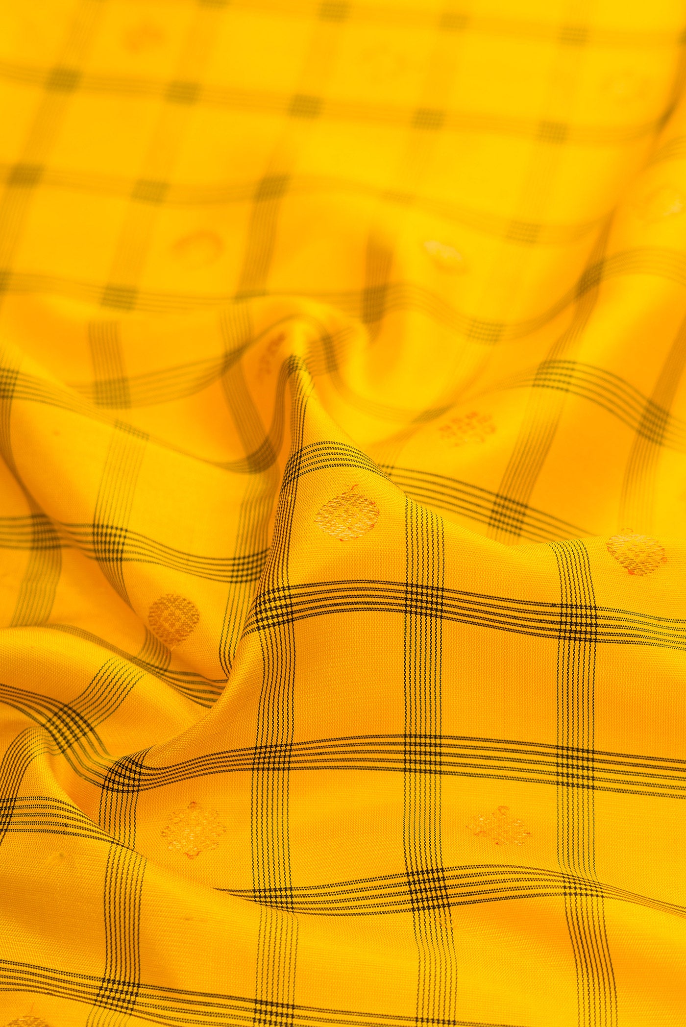 Close up of Yellow Gadwal Silk Saree with Checked design on the body and Zari Border.  displaying folds