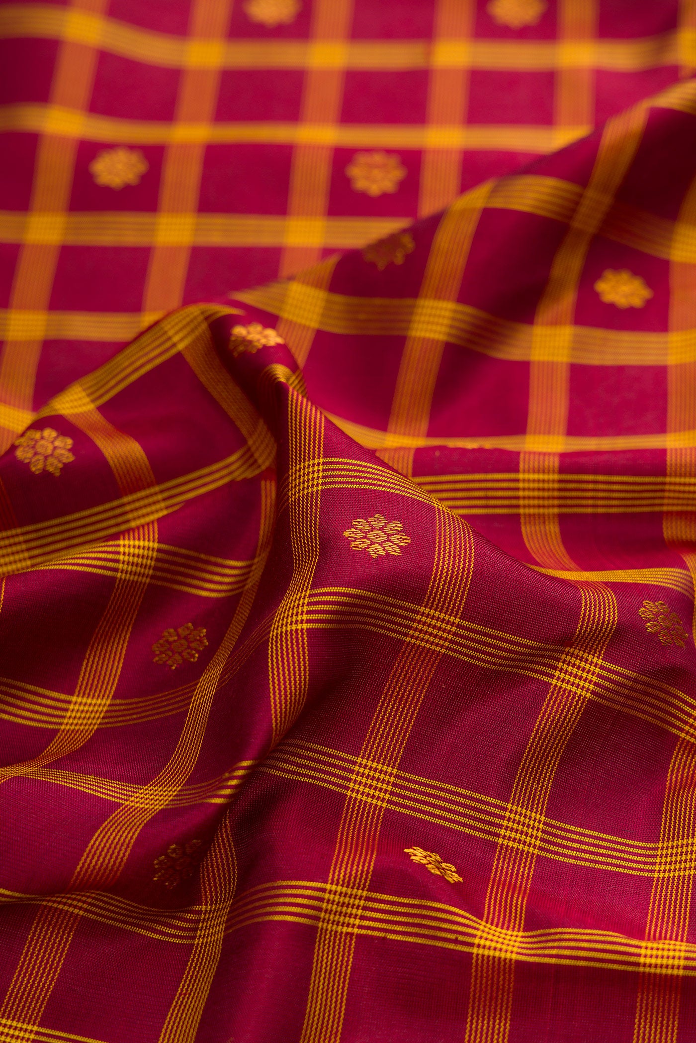 Close up of Maroon Gadwal Silk Saree with Checked design on the body and Zari Border.  displaying folds