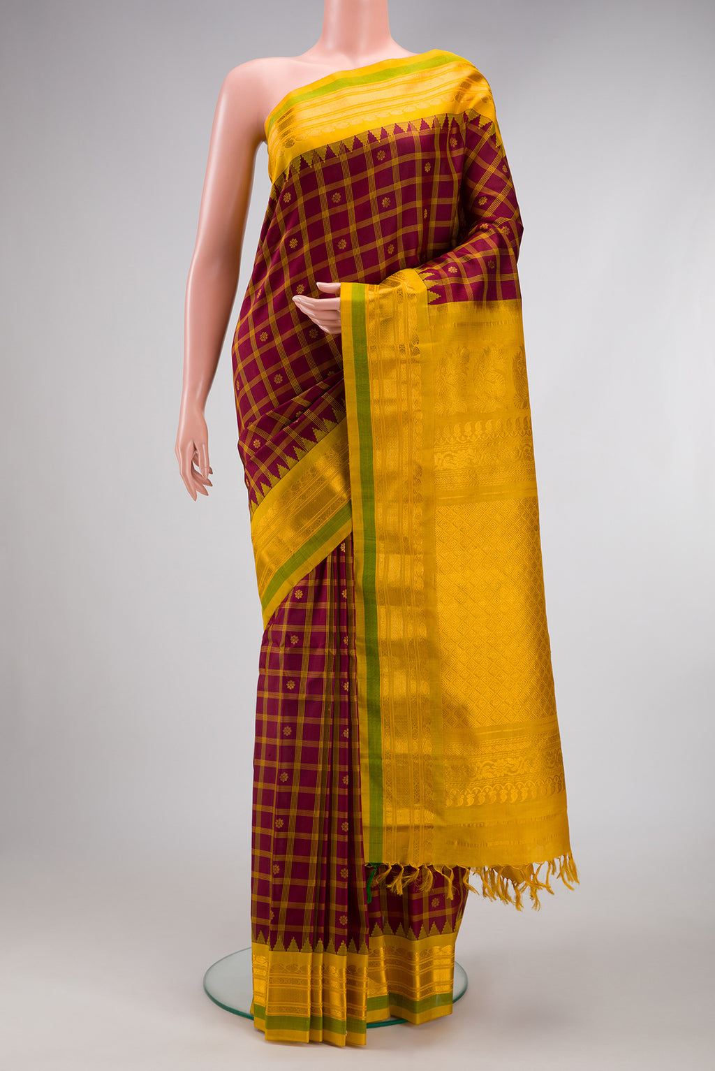 Maroon Gadwal Silk Saree with Checked design on the body and Zari Border.  displayed on a mannequin