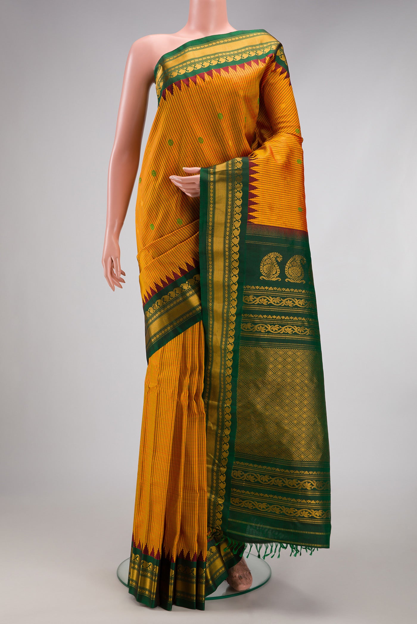 Mustard Gadwal Silk Saree with Checked design on the body and Temple Border.  displayed on a mannequin