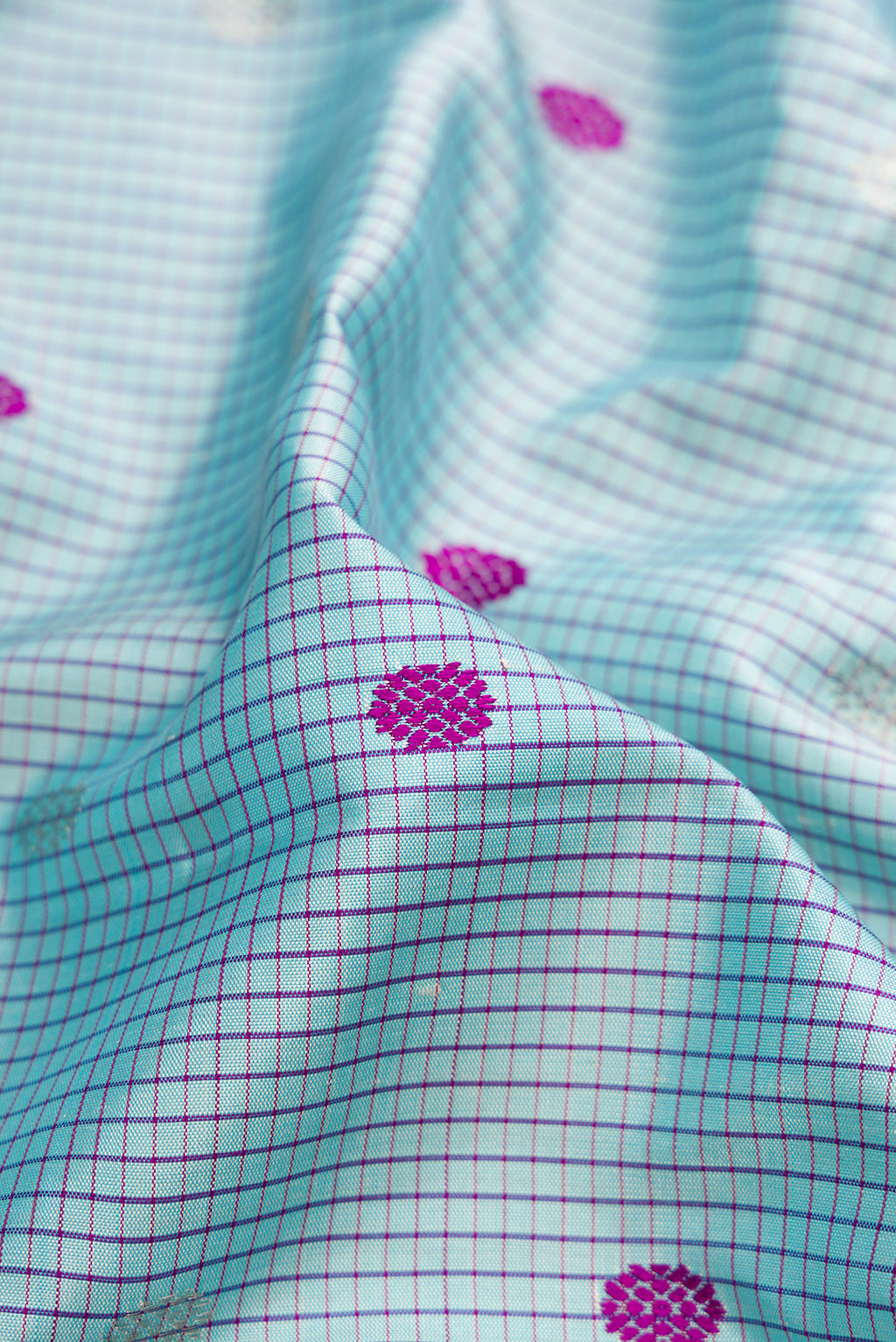 Close up of Sky Blue Gadwal Silk Saree with Checked design on the body and Temple Border.  displaying folds